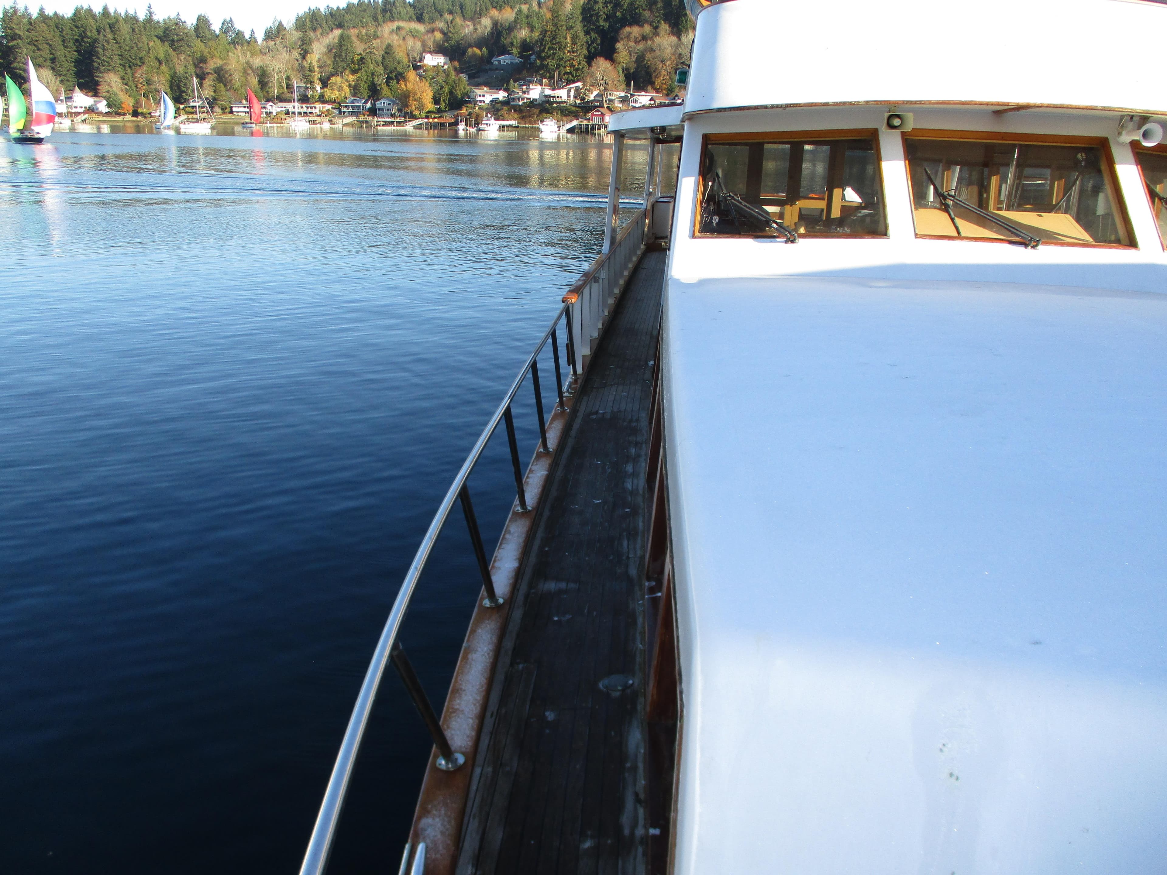 1984 McQueen Flush Deck Motoryacht on serene water with scenic background.