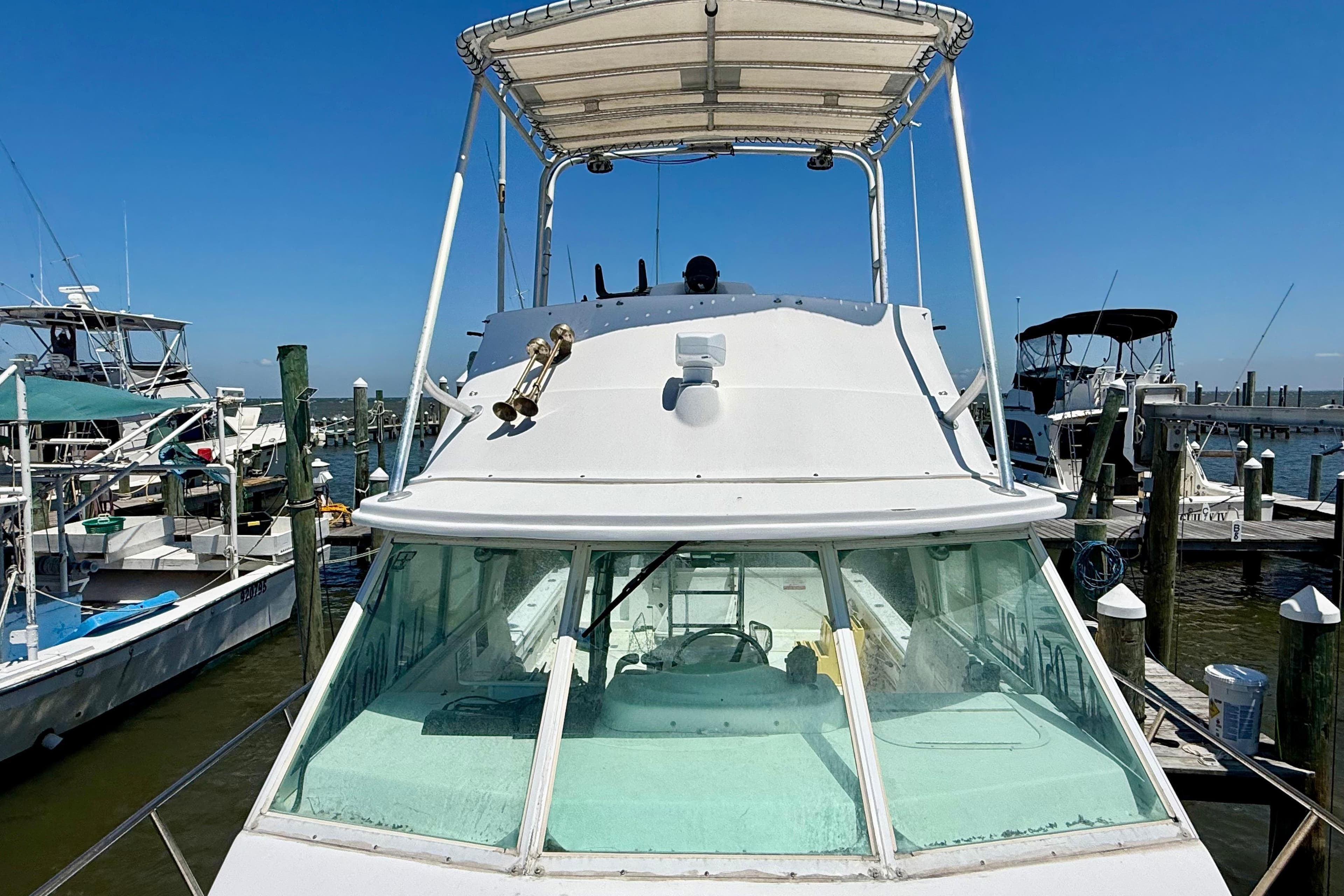 2000 BAJA CRUISER King Cat 340 docked at marina under clear blue sky.