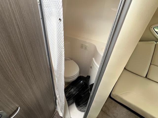 2019 Regal 26 Express boat interior bathroom with toilet and seating area.