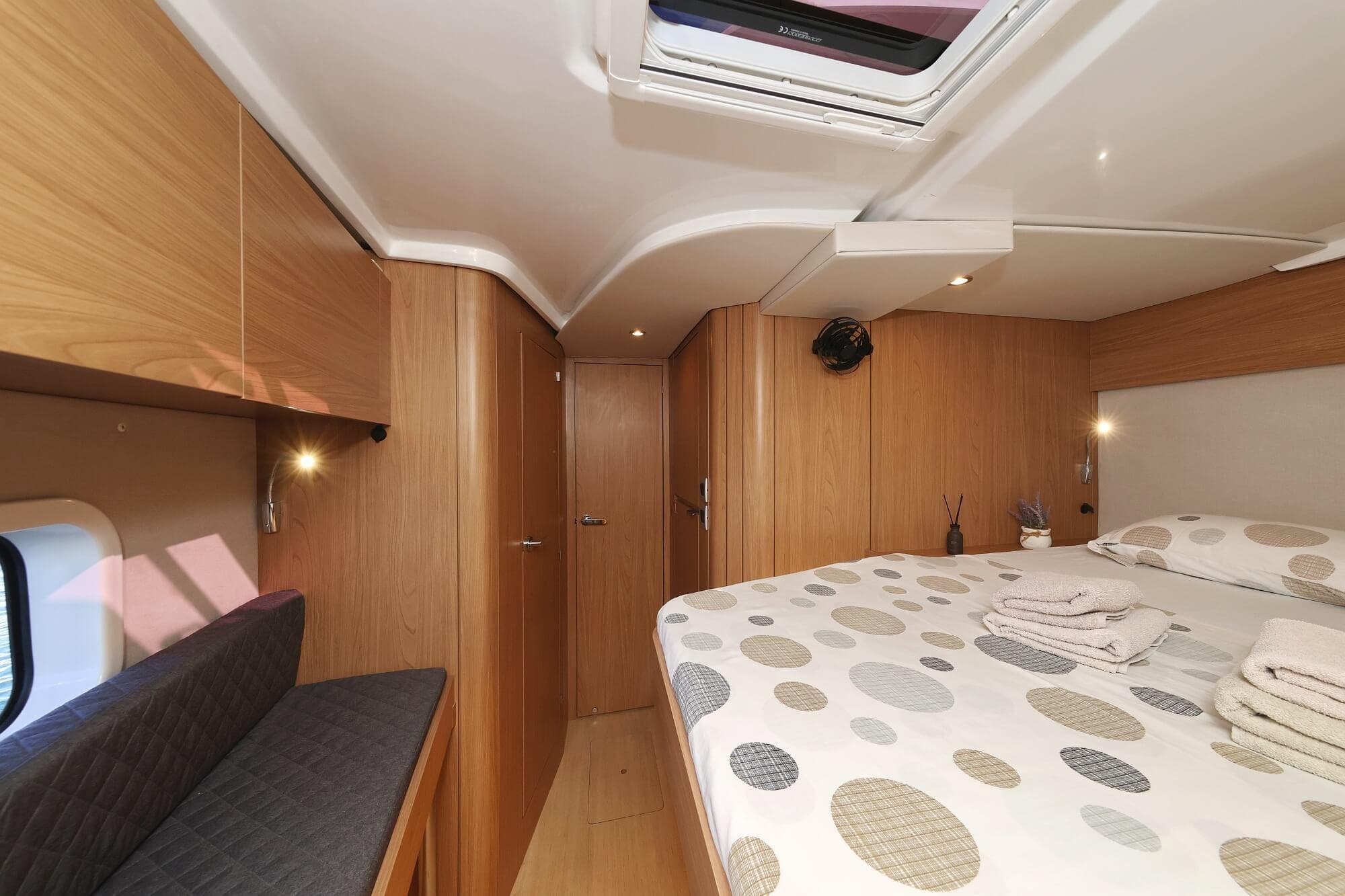 Luxurious 2025 Bali CATSPACE yacht cabin with modern wood finish and cozy bedding.
