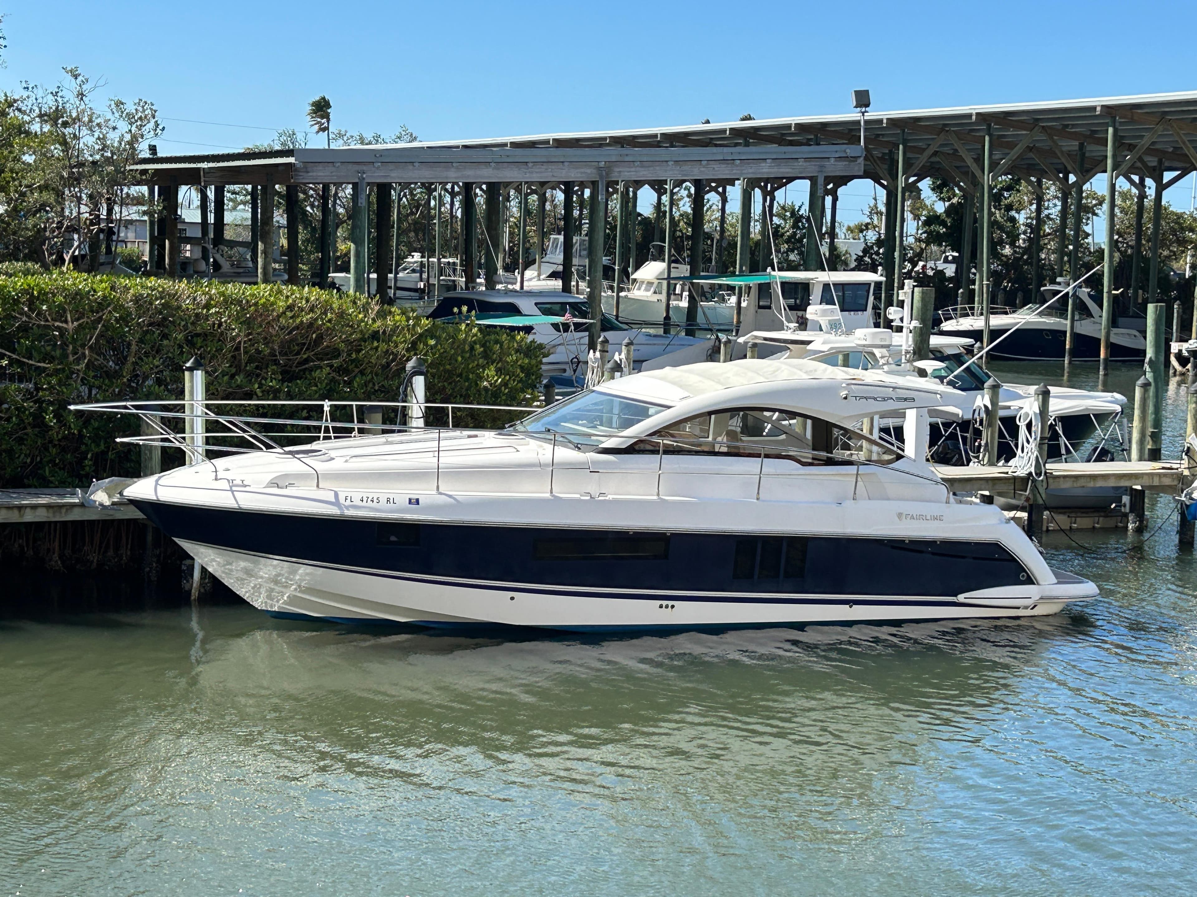 2013 Fairline Targa 38 Open yacht docked in a marina, surrounded by water and greenery.
