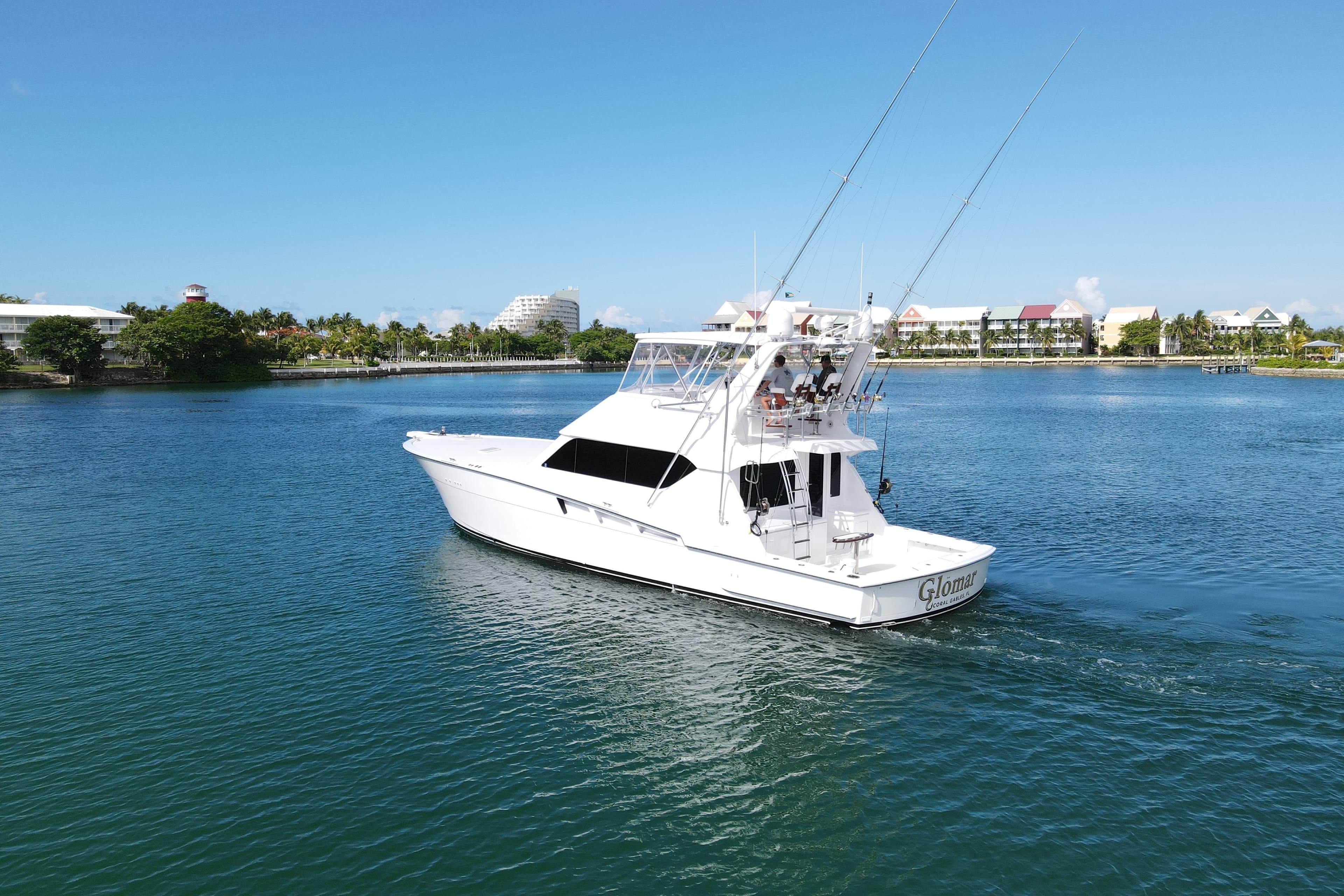 2004 Hatteras 60 Convertible yacht cruising in a scenic coastal area.
