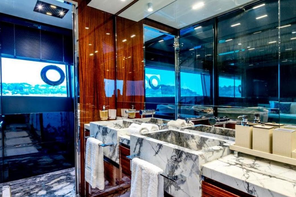Luxurious bathroom interior on 2021 Riva 88' Folgore yacht with marble sink and modern design.