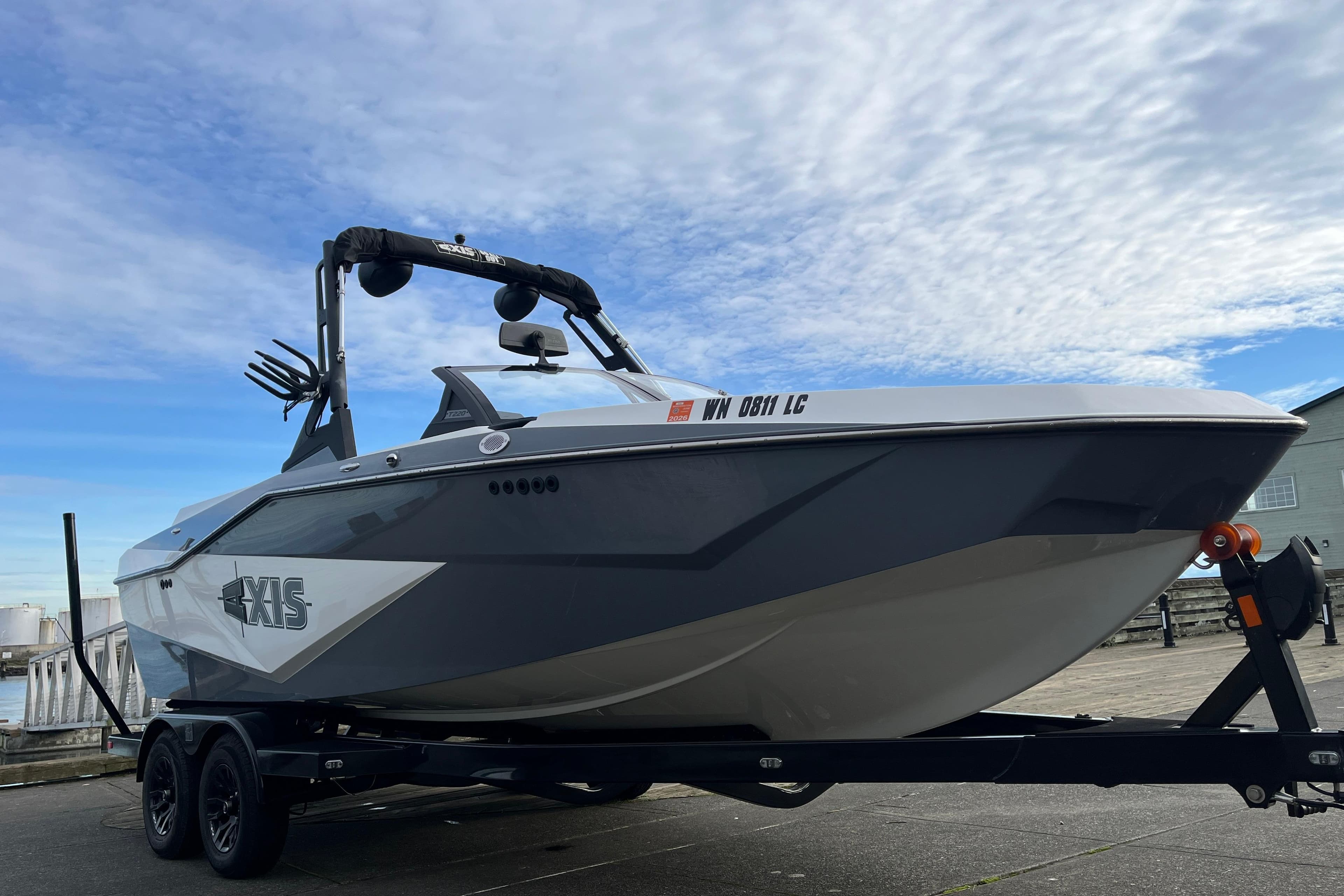 2024 Axis T220 boat on trailer under a partly cloudy sky.
