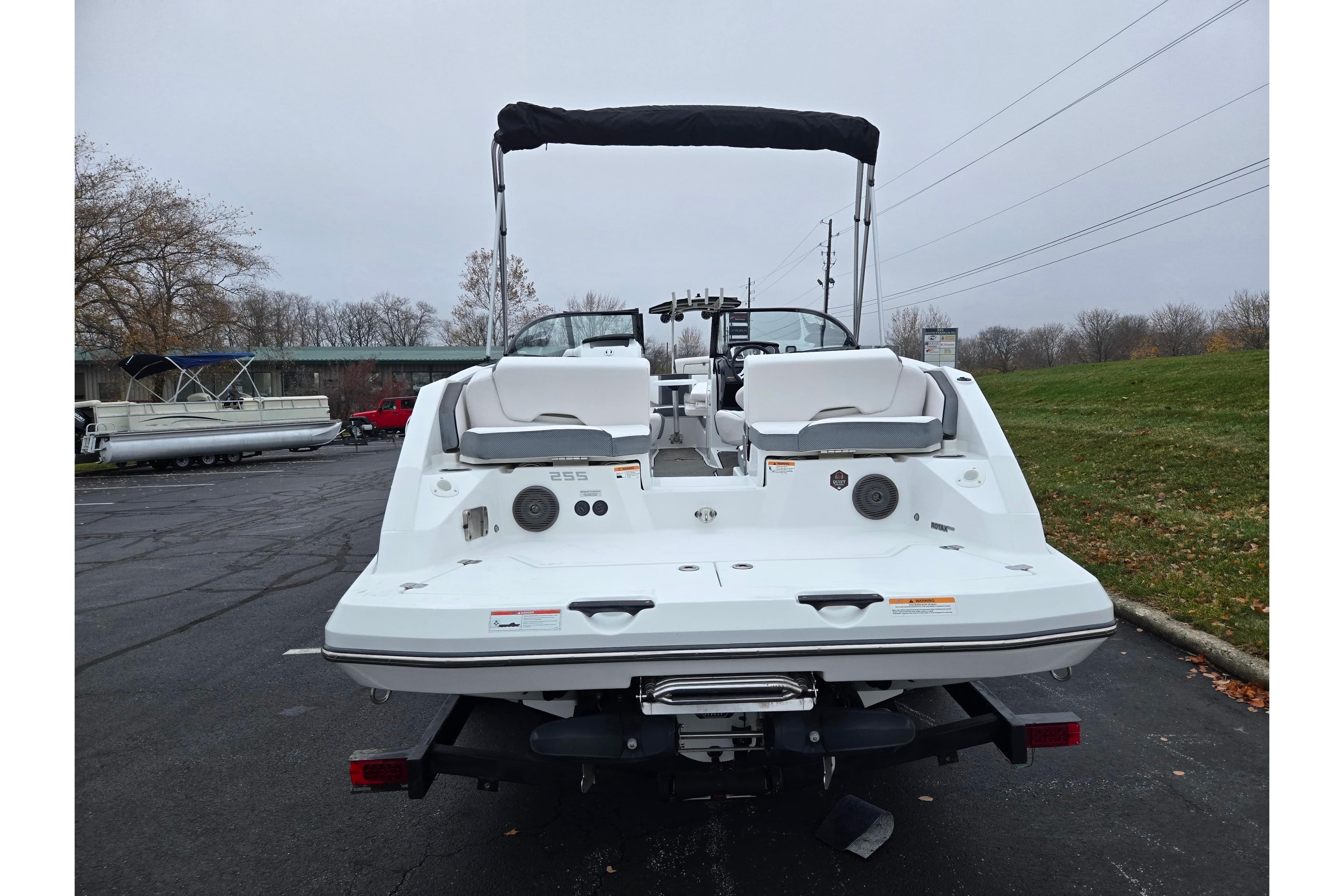 Rear view of a 2021 Scarab 255 ID boat parked outdoors on a cloudy day.