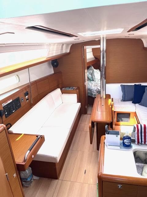 Interior of 2019 Jeanneau Sun Odyssey 389 sailboat with modern furnishings and cozy seating.