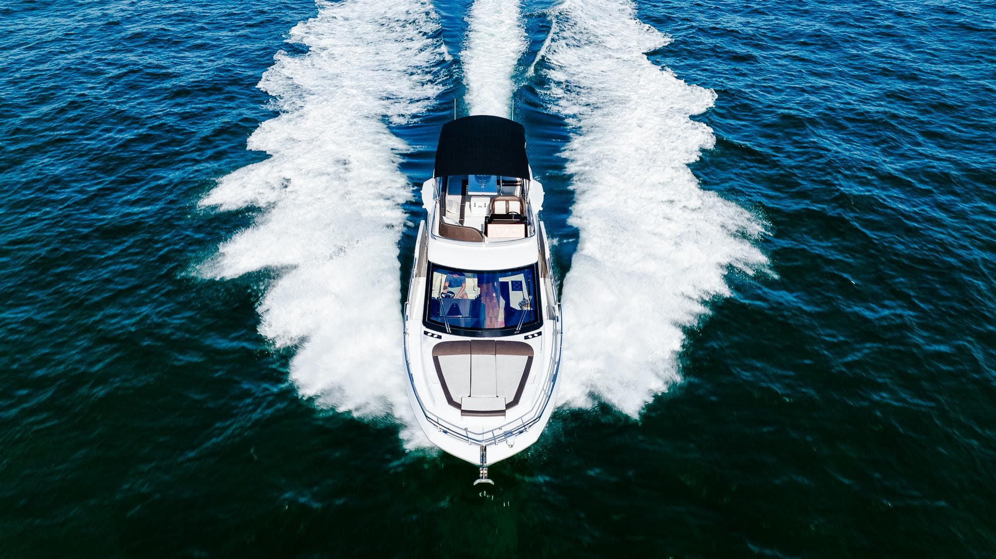 2022 Galeon 400 Fly yacht cruising on open water, aerial view.