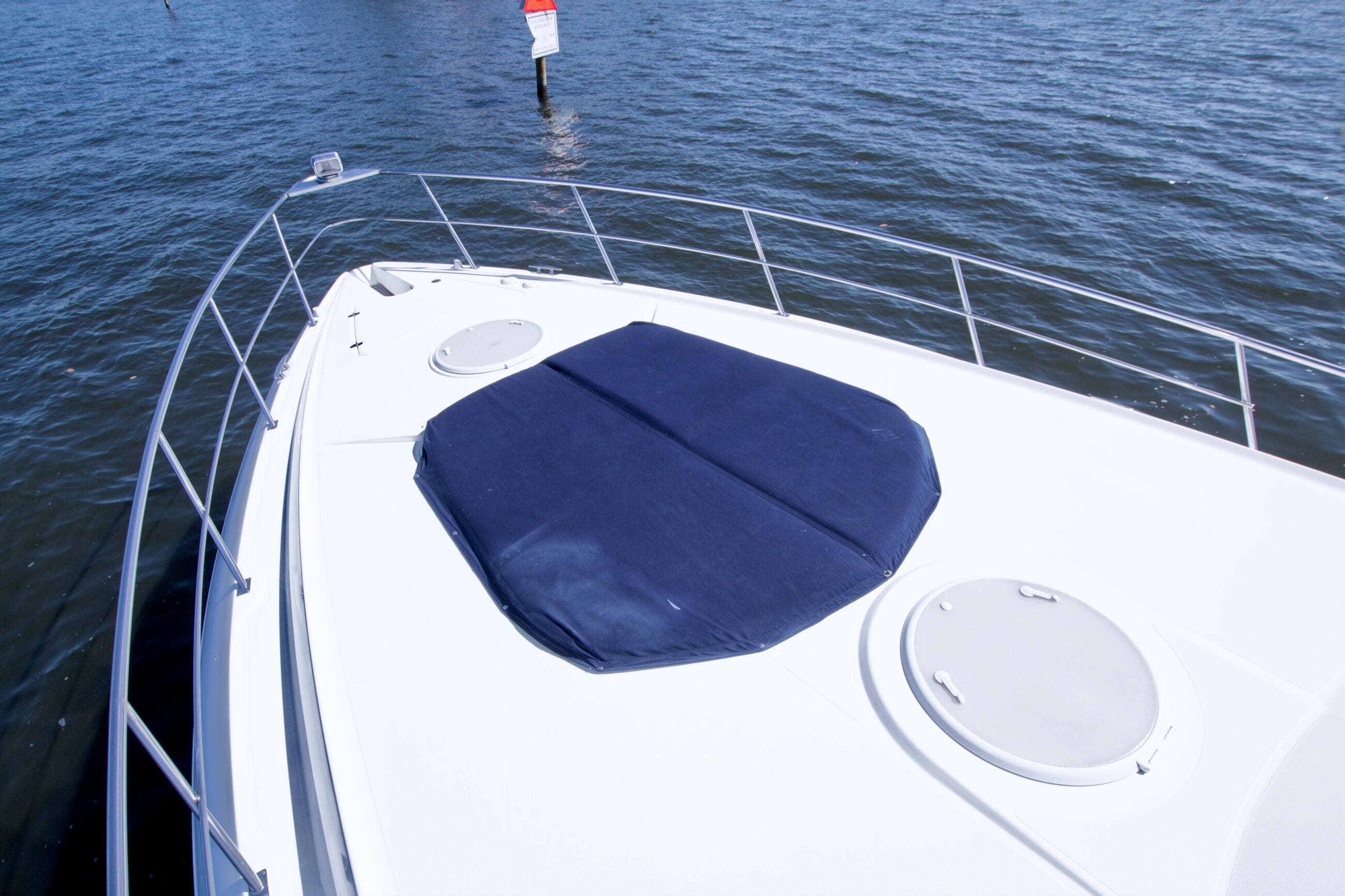2008 Cruisers Yachts 420 Express bow with blue sunpad on calm water.