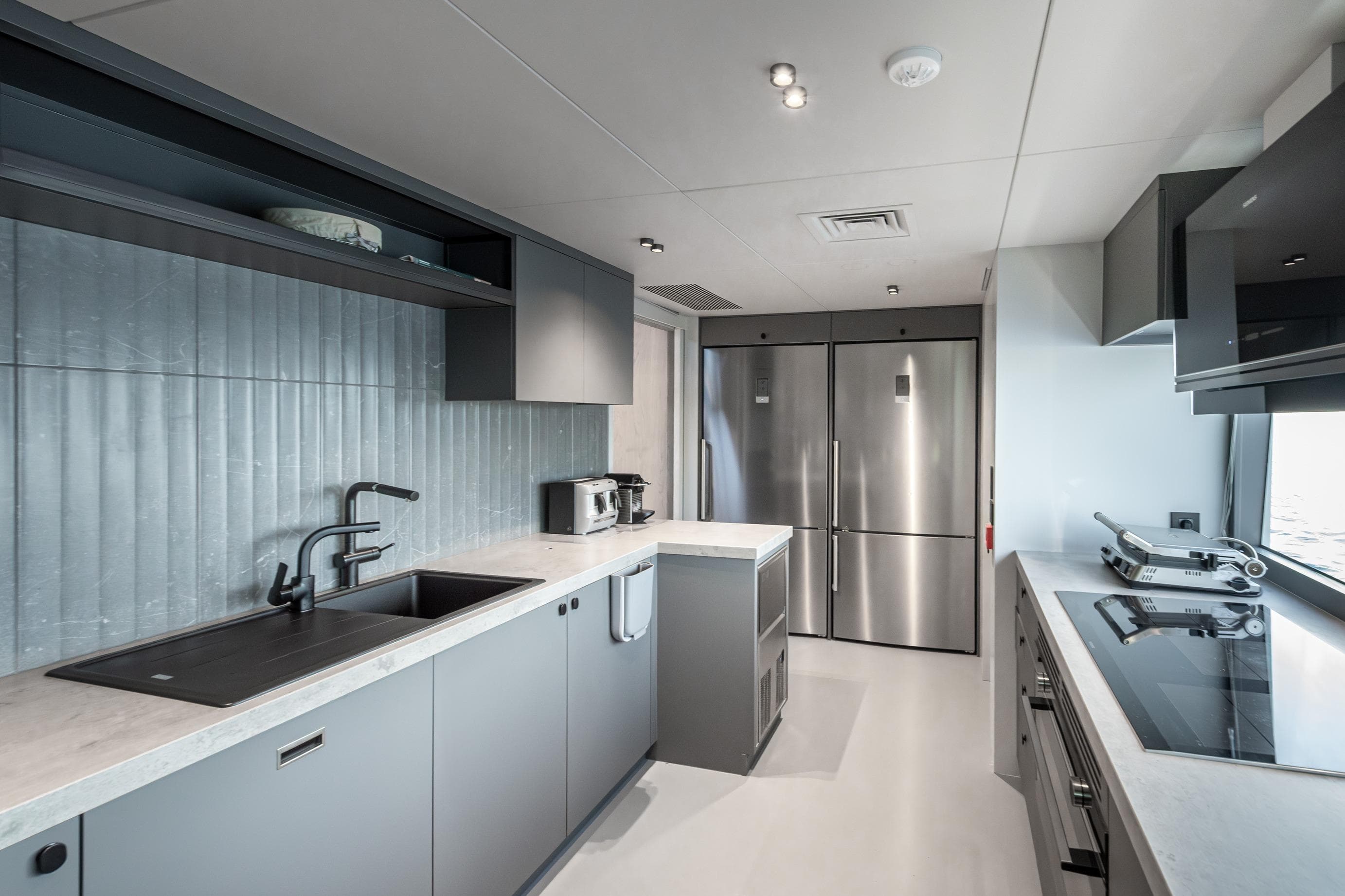 Modern kitchen interior on 2025 Numarine 30XP yacht, featuring sleek appliances and minimalist design.