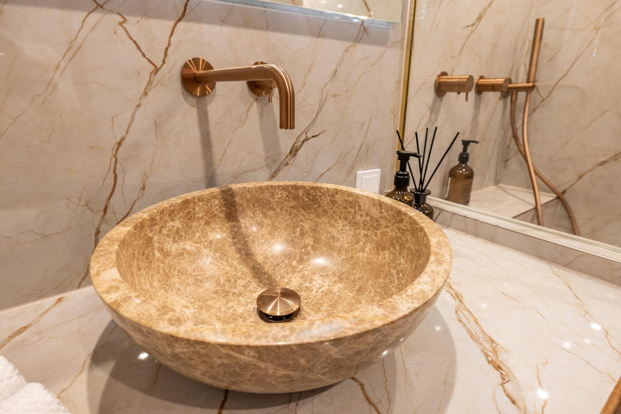 Elegant marble sink with gold faucet in luxurious bathroom setting.