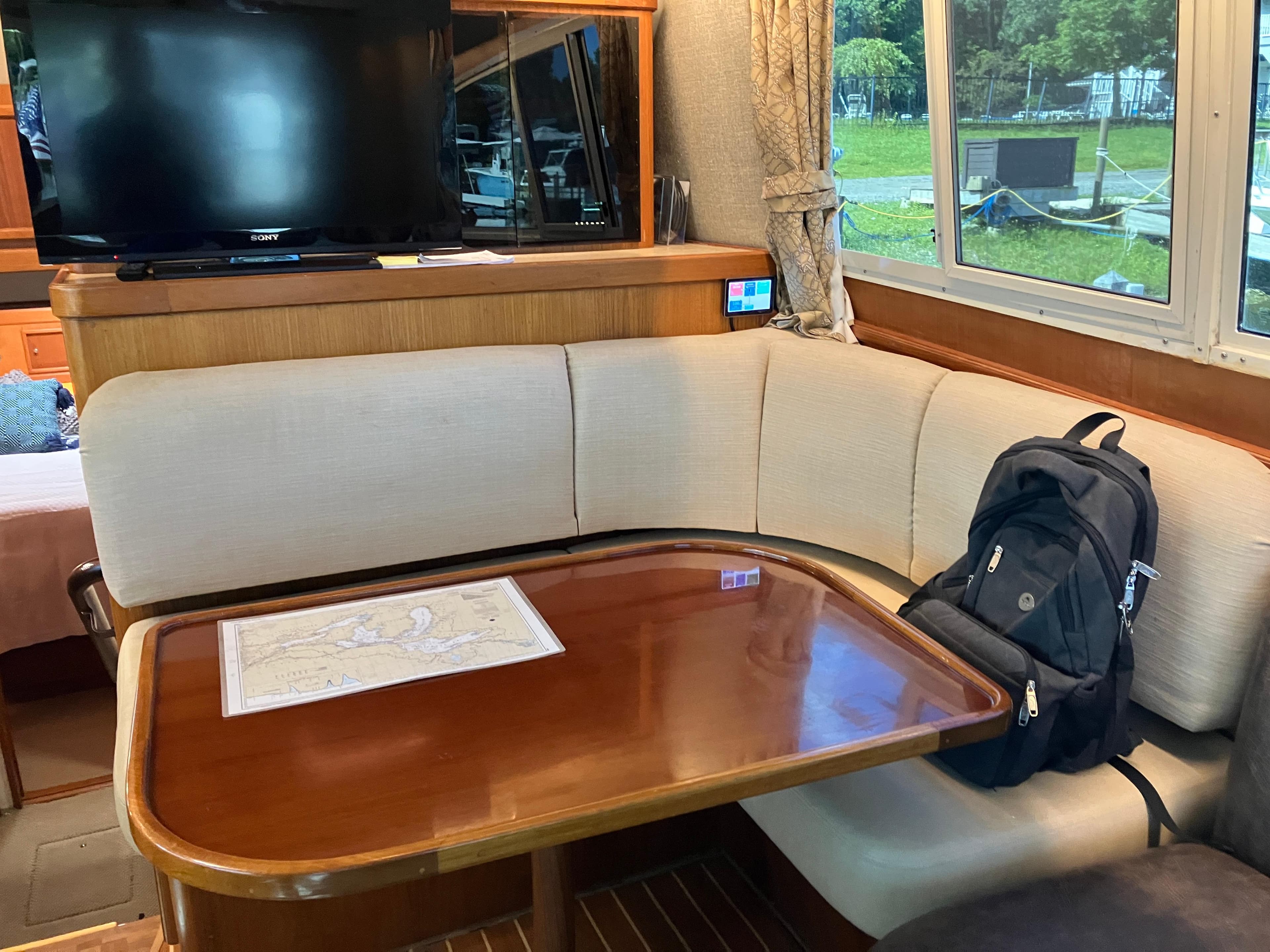 Interior of 1995 Egg Harbor 42 yacht with dining area, TV, and backpack.