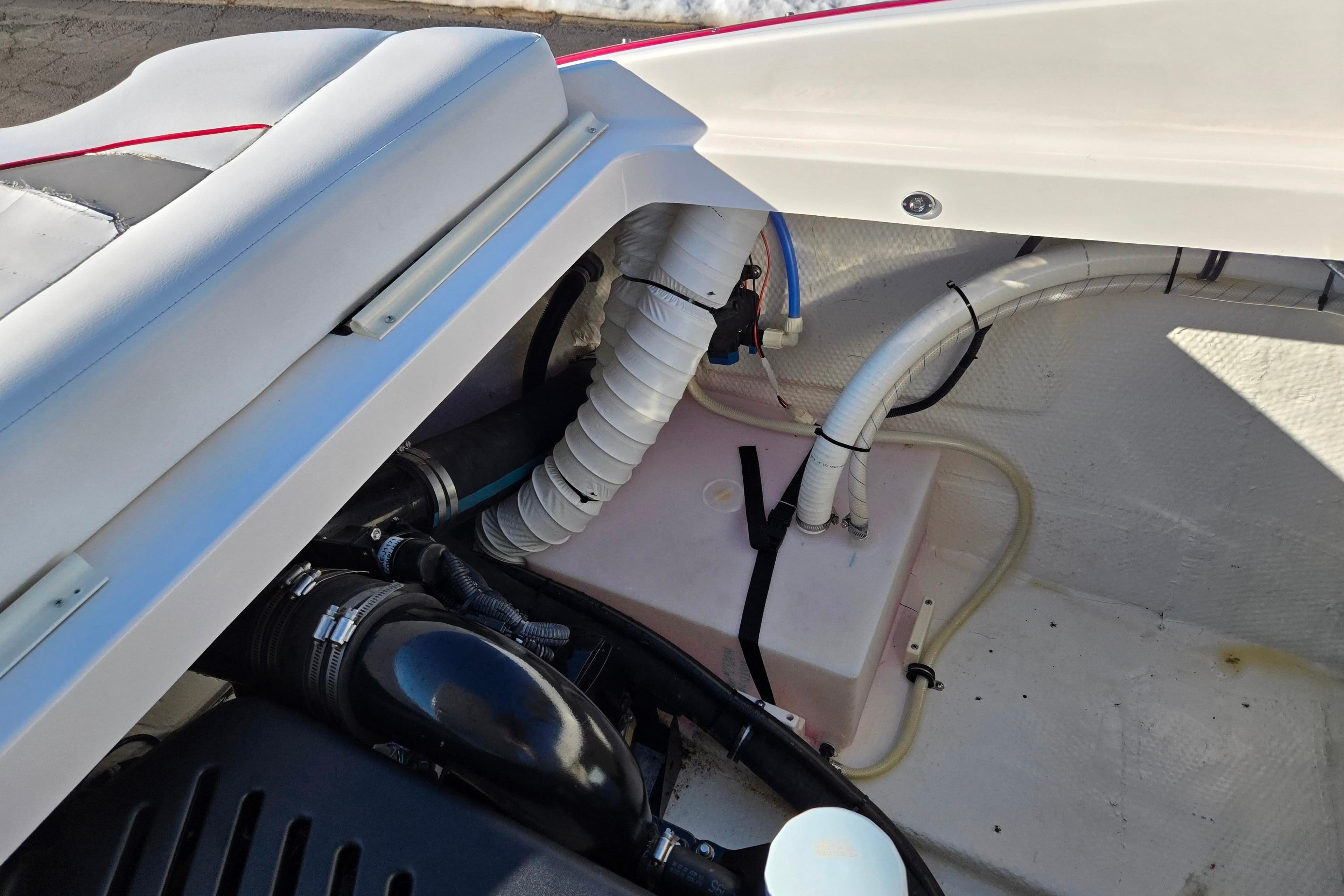 Engine compartment of a 2007 Rinker 262 Captiva Cuddy boat, showing hoses and components.