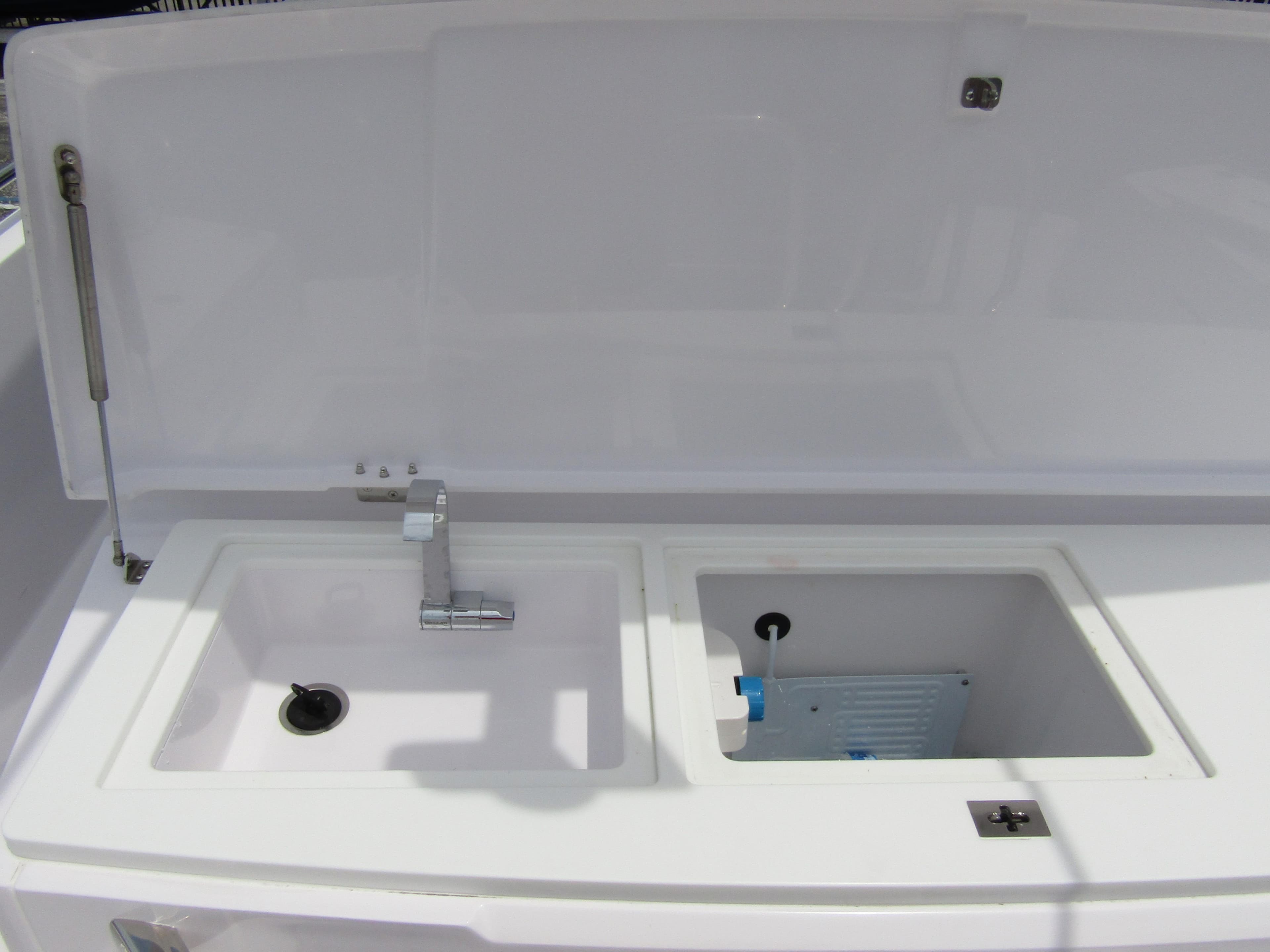 2024 Axopar 37 Sun Top boat sink and storage area with open lid.