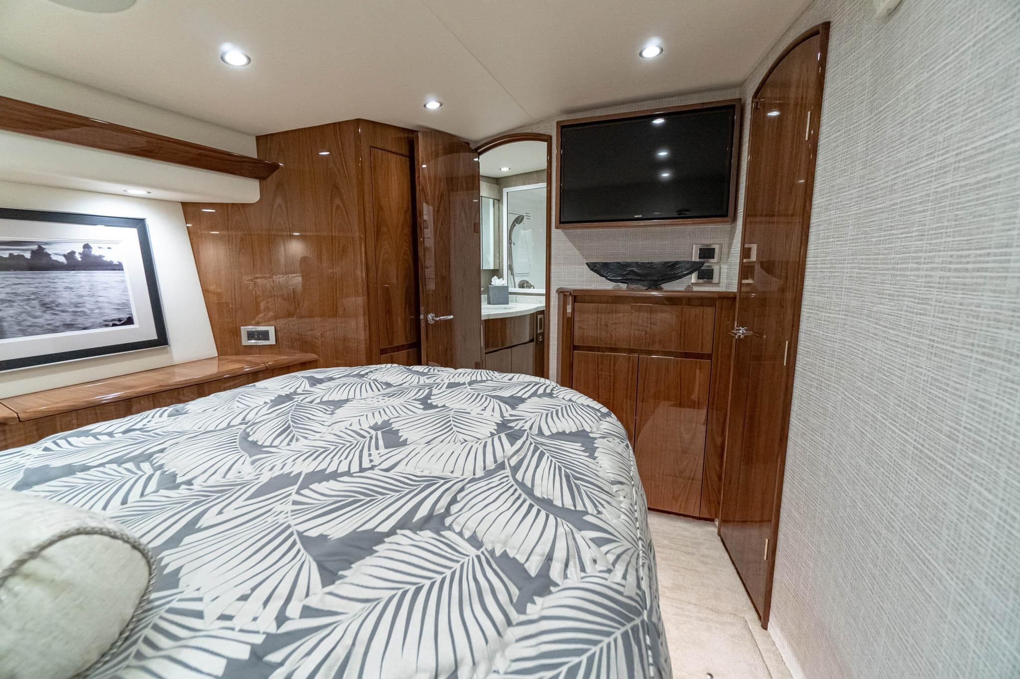 Luxurious bedroom interior of 2026 Viking 54 Convertible yacht with modern decor and amenities.