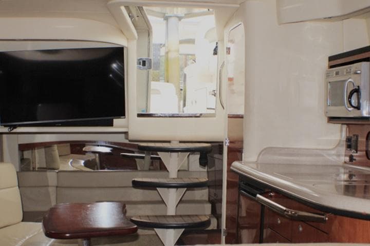 Interior of 2007 Sea Ray 340 Sundancer yacht with TV, kitchenette, and stairs.