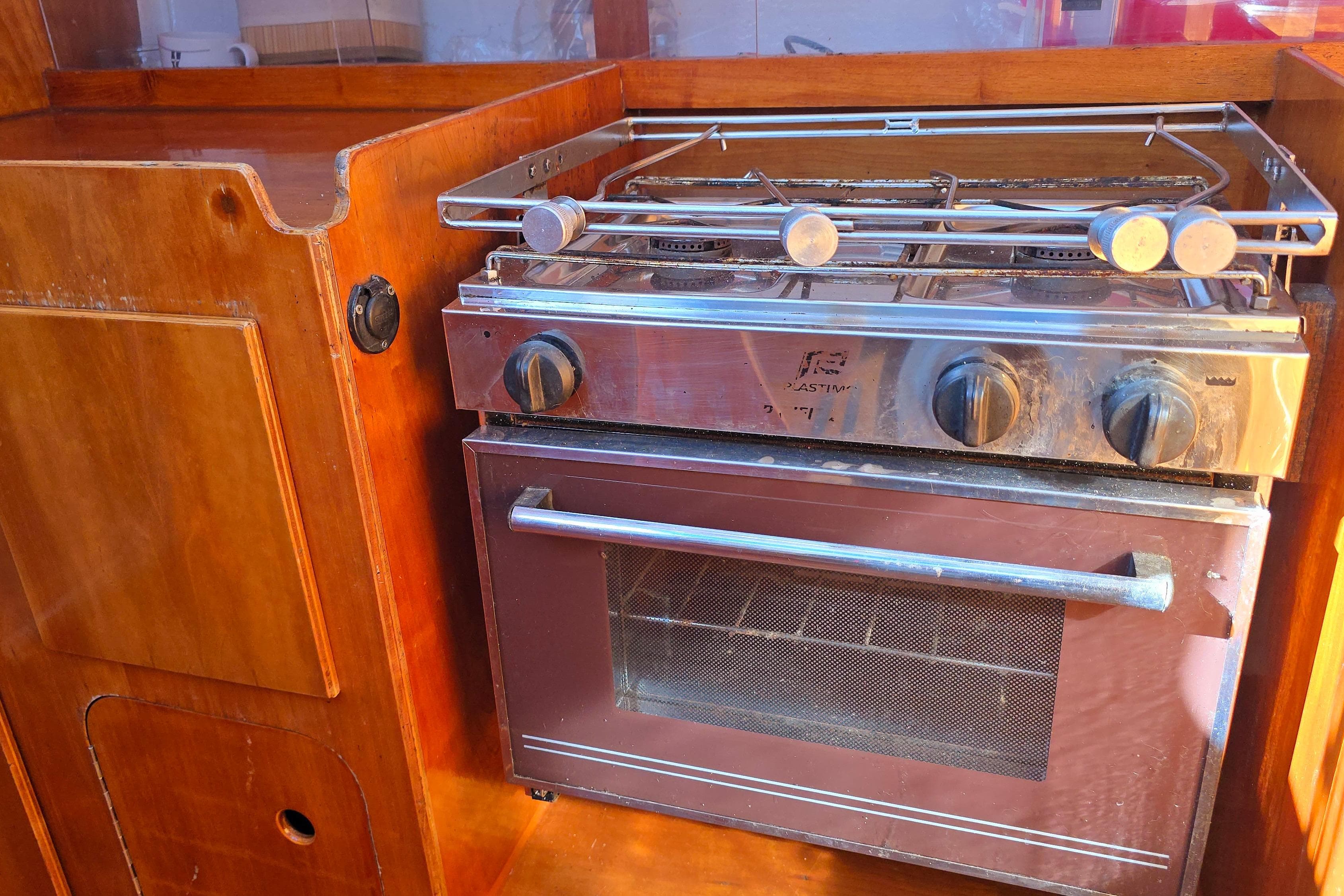 Wooden boat kitchen with a stainless steel stove and oven, FF Boats 1100, 2003 model.
