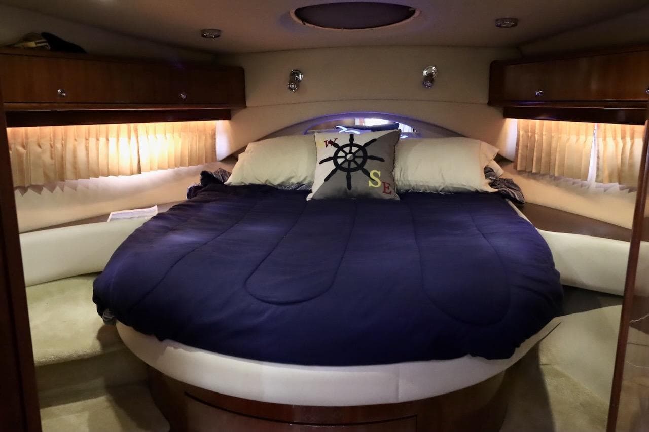 Luxurious 2006 Regal Commodore 4460 yacht bedroom with cozy bedding and nautical decor.