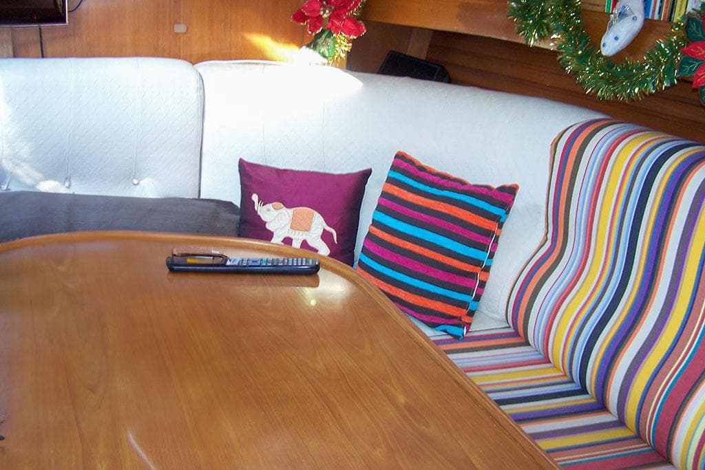 Cozy interior of 1990 Wauquiez Centurion 47 with colorful cushions and festive decor.