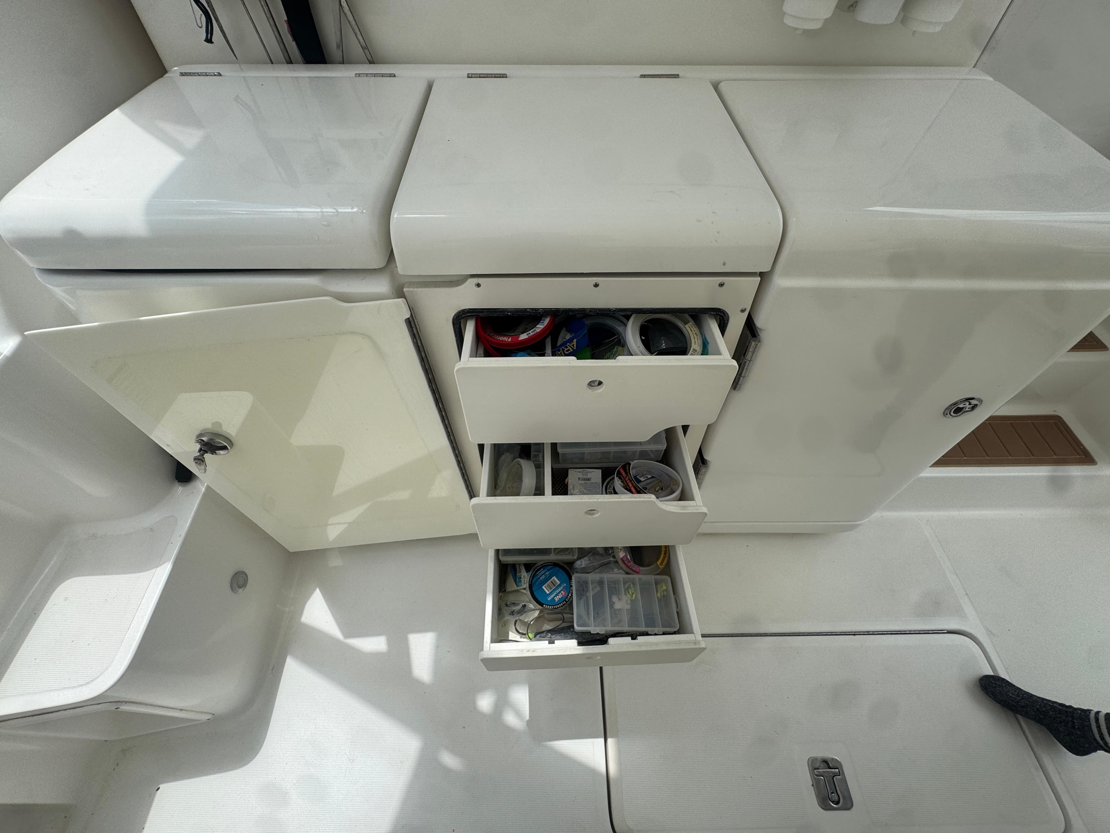 Storage compartments on a 2006 Tiara Yachts 4200 Open, featuring open drawers and organized supplies.