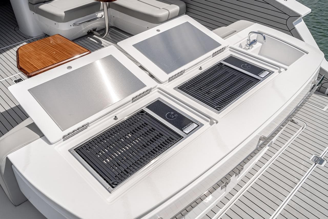 Outdoor kitchen on the 2024 Cruisers Yachts 50 GLS with dual grills and sink.