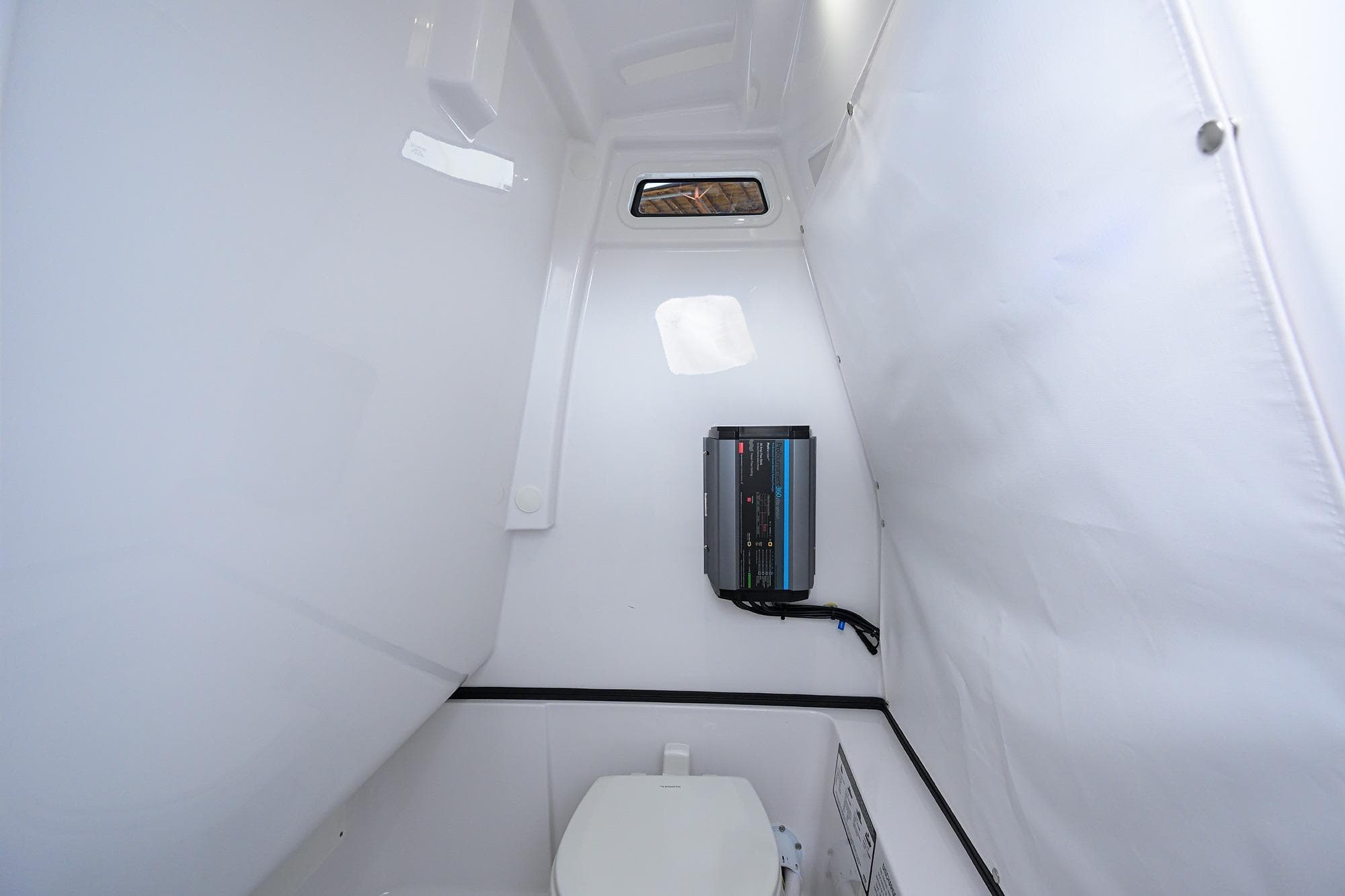 Interior of 2026 Sportsman Heritage 261 Center Console boat, featuring a compact marine toilet.