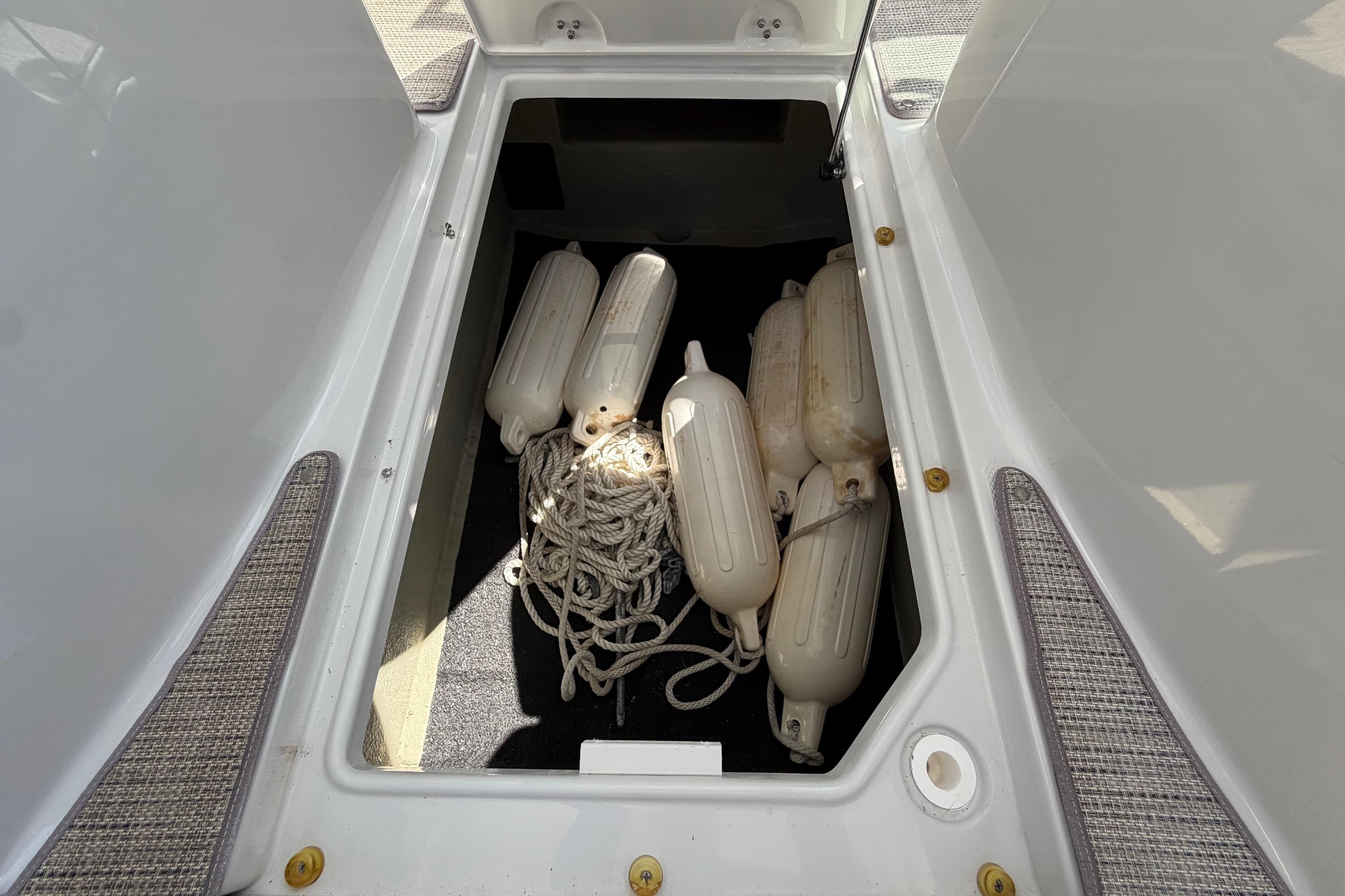 Storage compartment of 2019 Crownline Eclipse E295 XS with boat fenders and ropes.