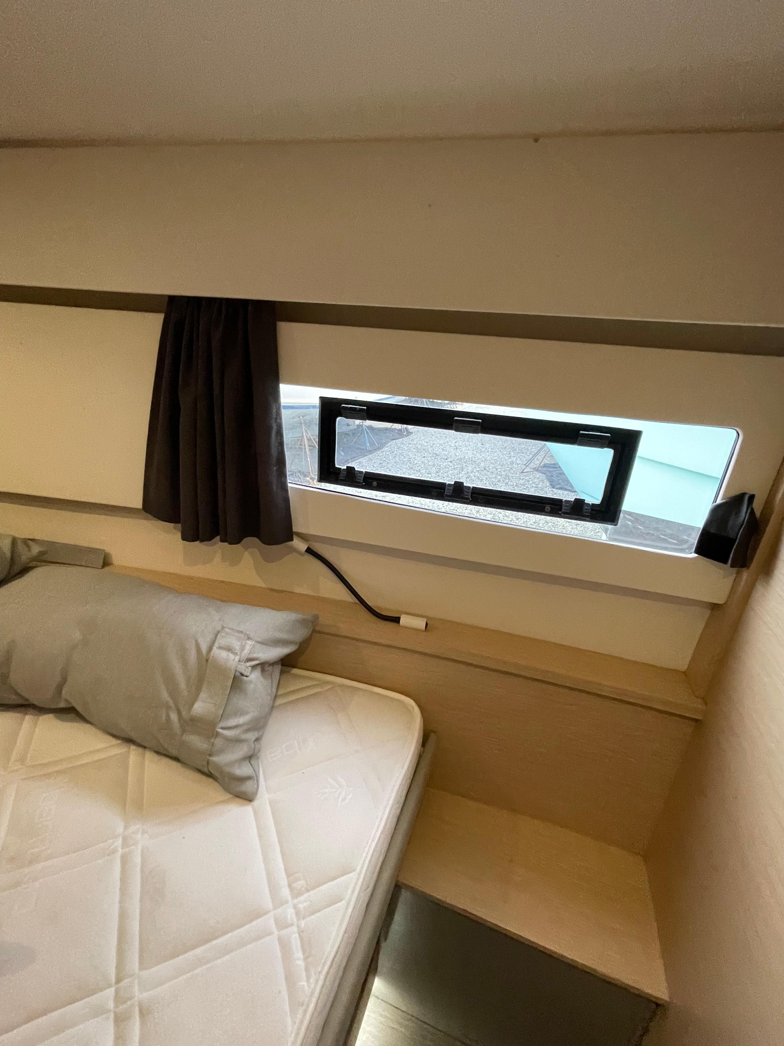2018 Fountaine Pajot MY 37 cabin interior with bed, window, and curtain.
