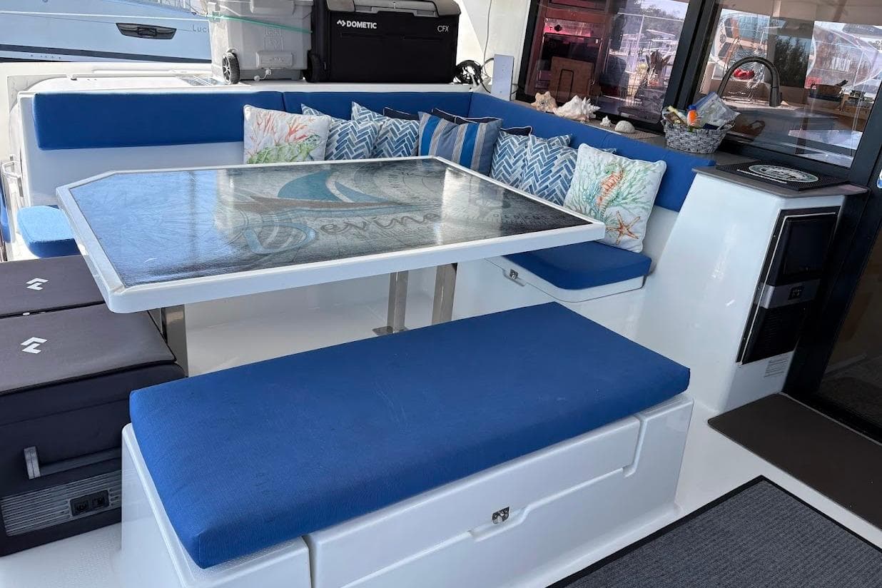 Luxurious 2015 Fountaine Pajot SABA 50 yacht interior with blue seating and decorative pillows.