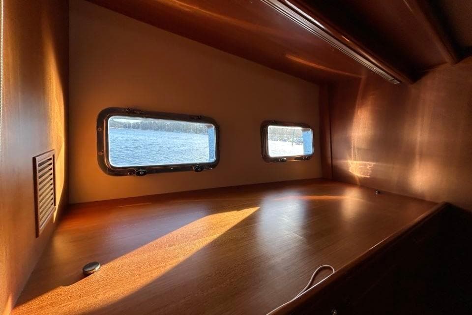 Interior view of 2008 Grand Banks 59 Aleutian RP yacht with wooden finish and porthole windows.