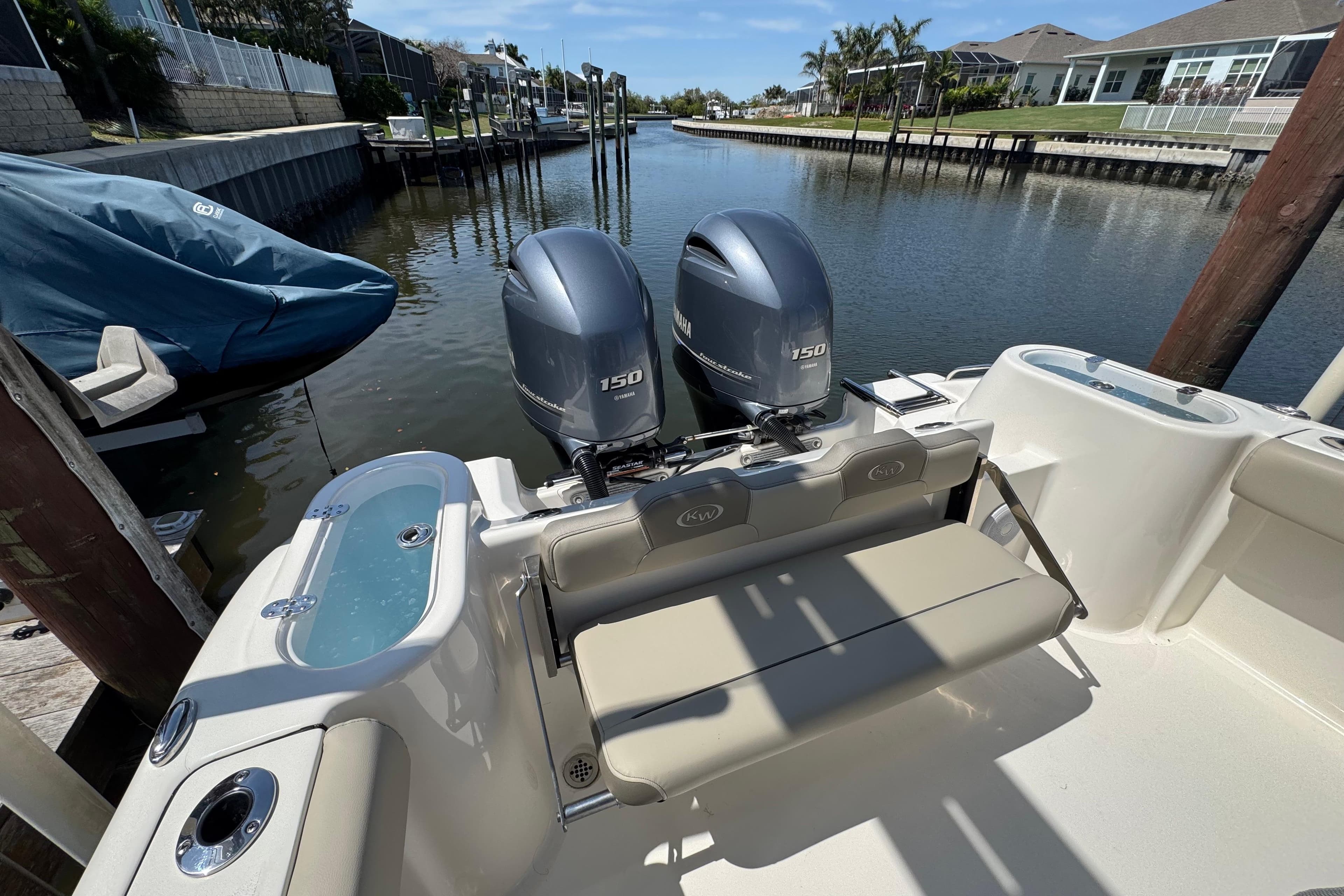 2022 Key West 244 Center Console boat with dual Yamaha 150 engines docked in a canal.