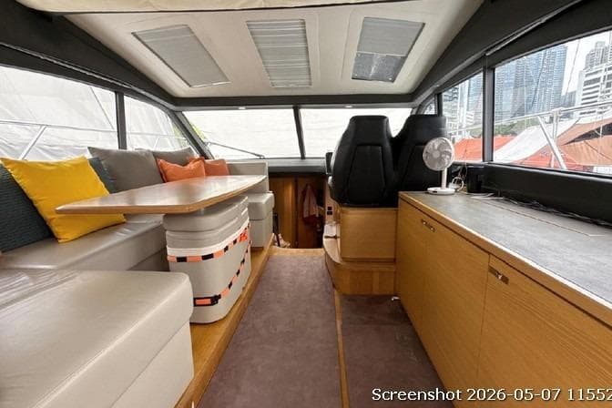 Interior of 2016 Princess V48 yacht with seating, table, and helm station.