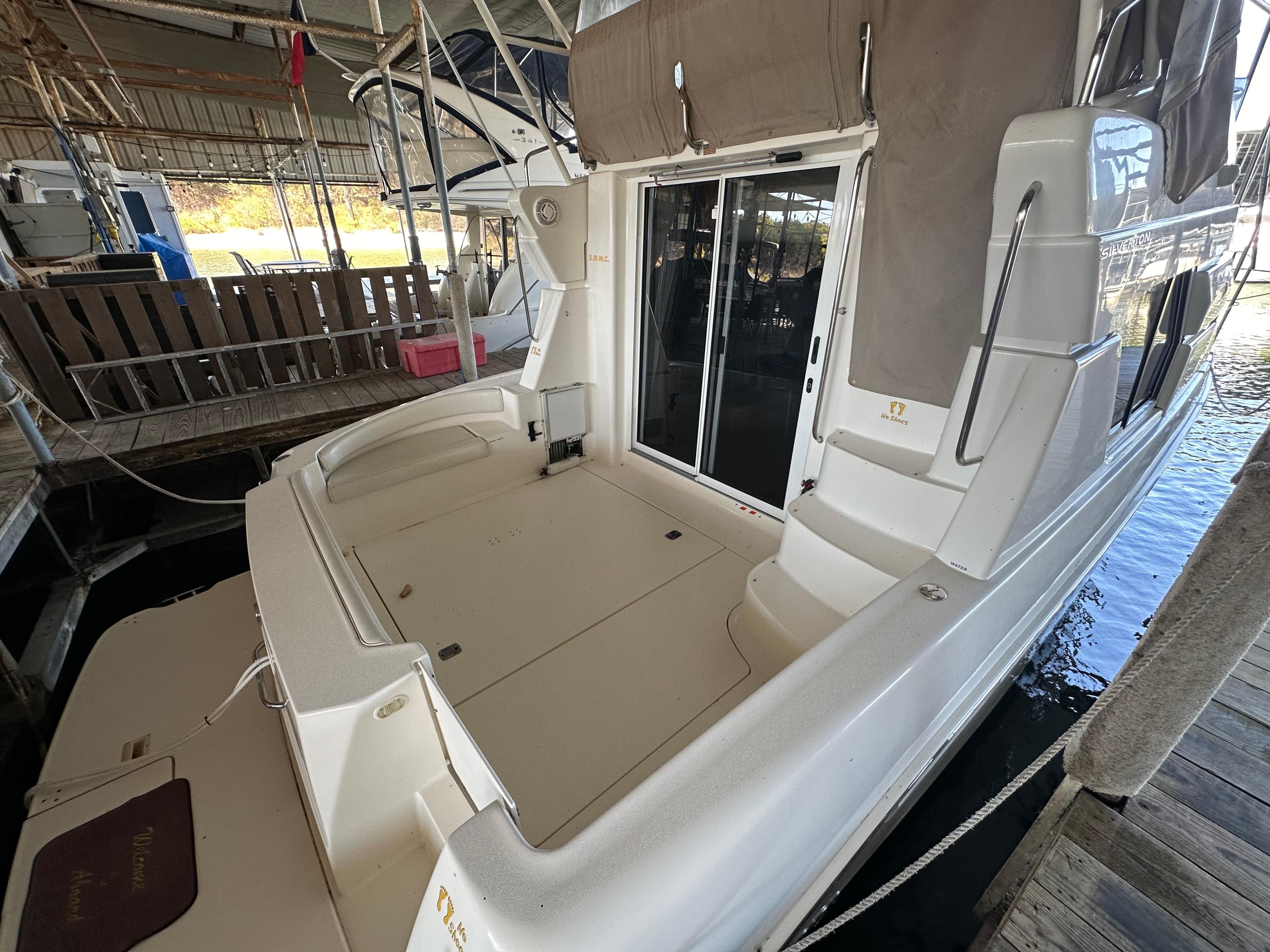 2002 Silverton 35 Convertible boat docked in a marina, rear view.
