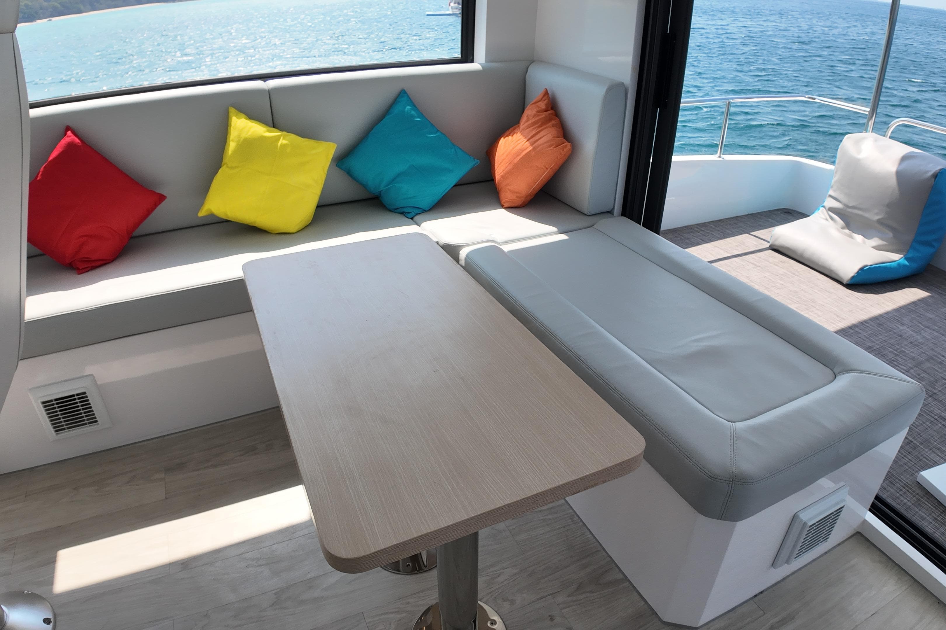 Luxurious Longreach 58 yacht interior with colorful cushions, ocean view, and modern seating, 2026 model.
