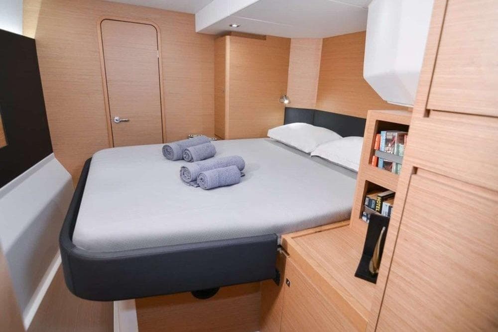 Luxurious cabin interior of 2020 Dufour Catamarans 48 with modern design and cozy bedding.