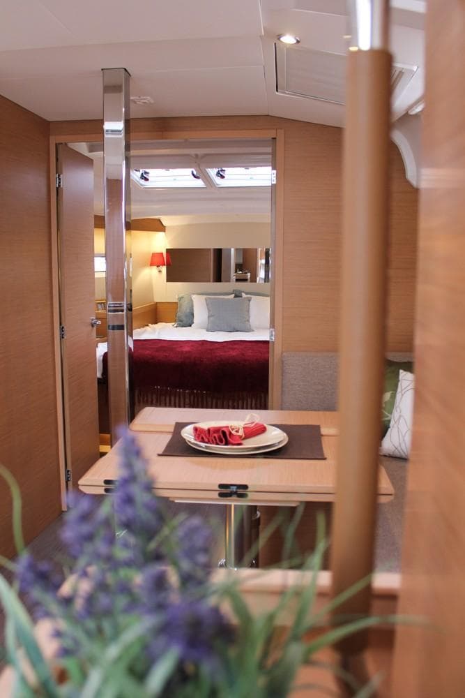 Interior of 2025 Jeanneau Sun Odyssey 440 yacht, featuring a cozy cabin and dining area.