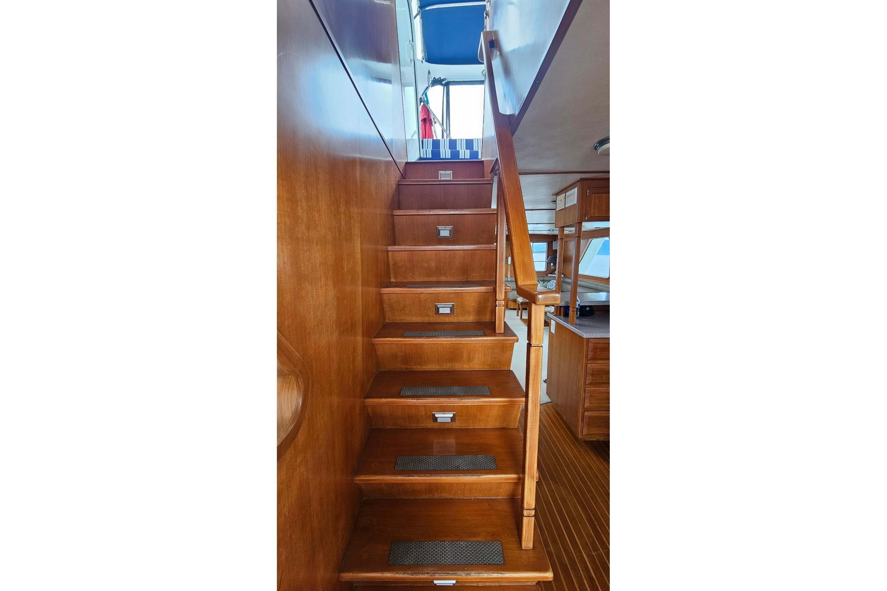 Wooden staircase inside 1987 DeFever 53 POC yacht, leading to upper deck.