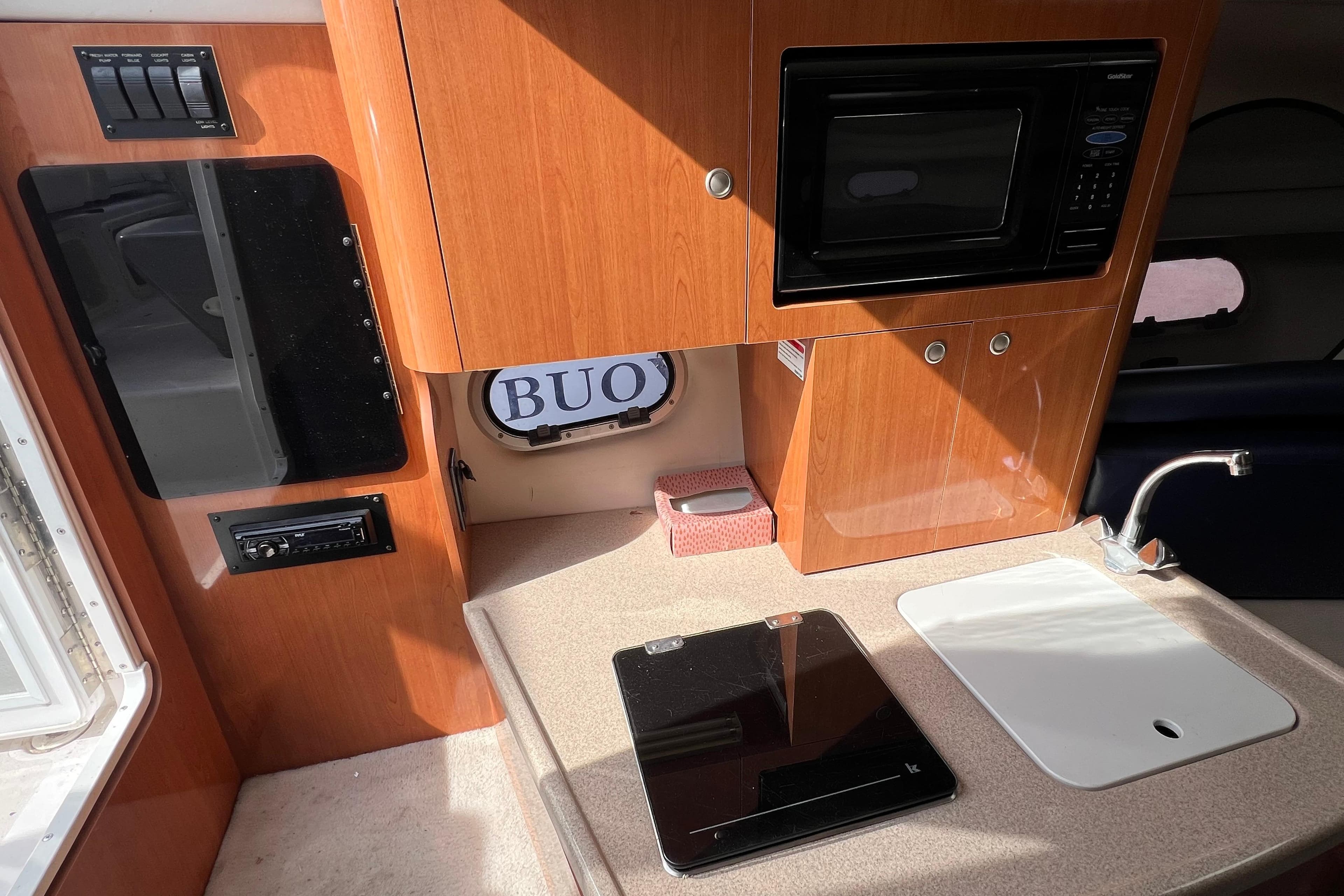 2001 Four Winns 268 Vista boat interior with kitchenette, microwave, and sink.