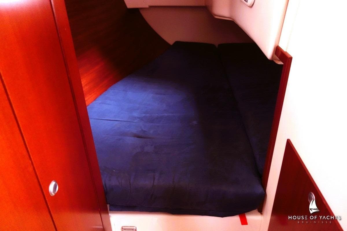 Cozy cabin interior of 2007 Hanse 315 yacht with dark bedding.