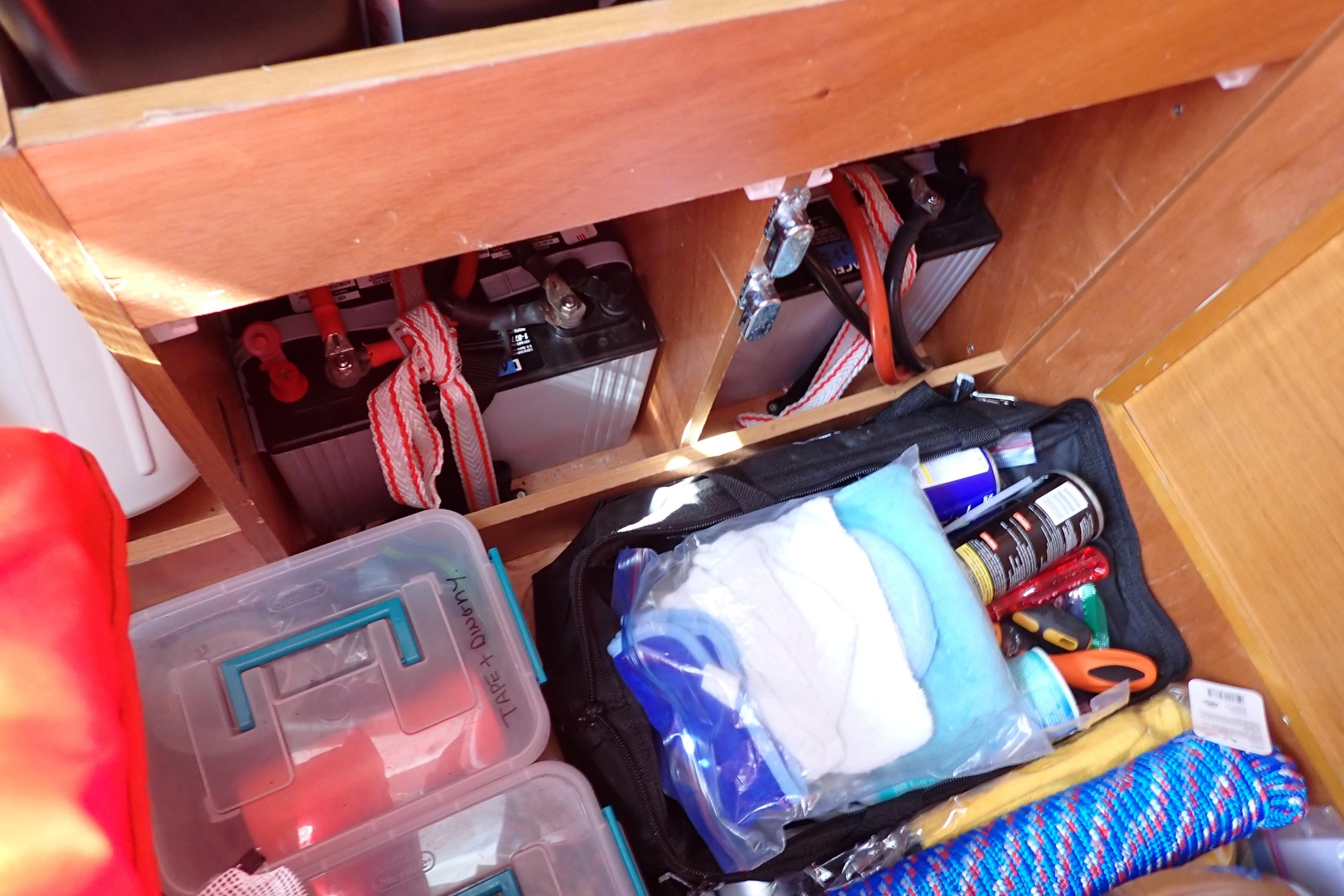Storage compartment in a 2018 Jeanneau Sun Odyssey 389, featuring batteries and maintenance supplies.