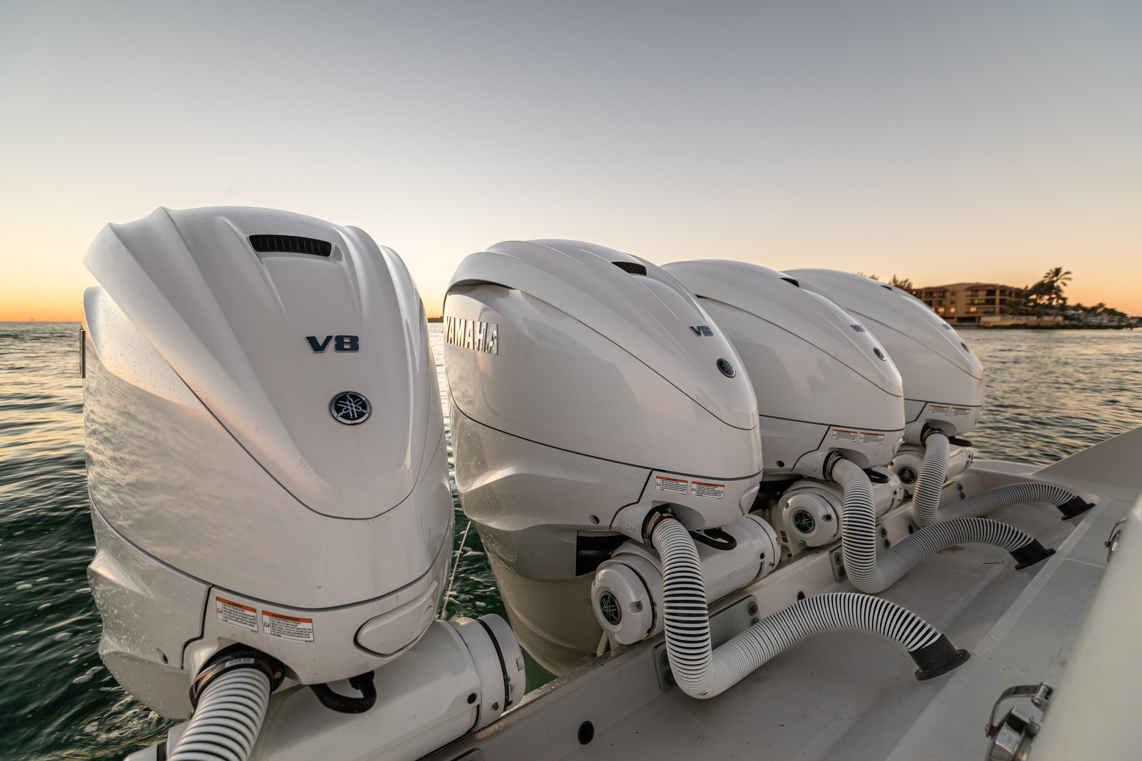 Four Yamaha V8 outboard engines on a 2018 HCB 53 Suenos RXV at sunset.