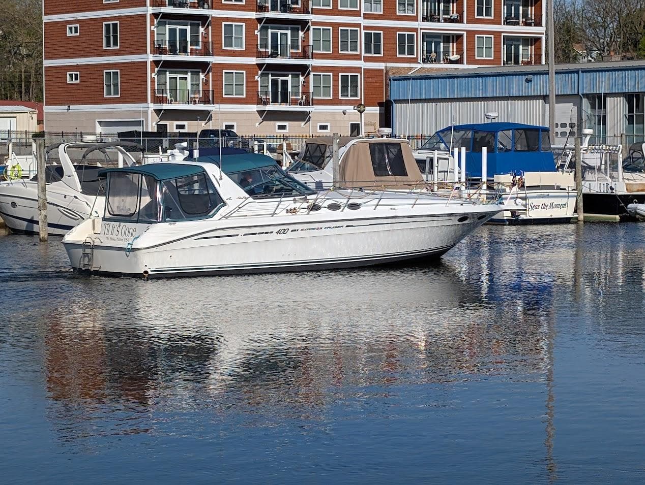 1995 Sea Ray 400 Express Cruiser docked in marina, reflecting on calm water.