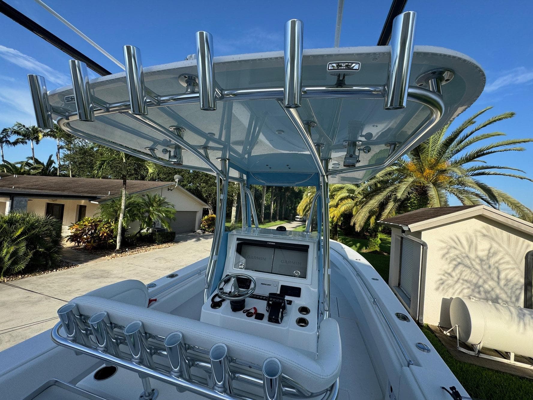 2024 Contender 32 ST boat with sleek console and rod holders, set against a tropical backdrop.