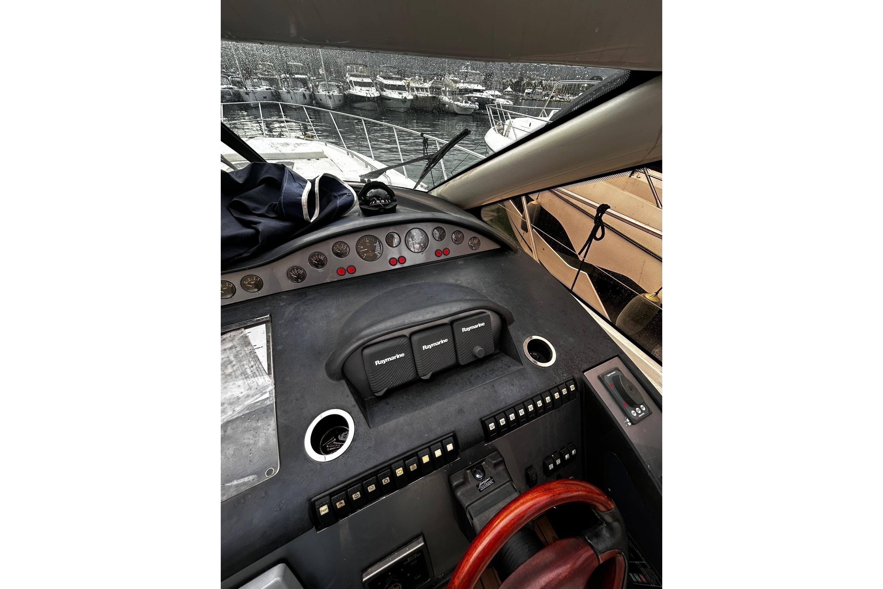Cockpit view of 2001 Princess V65 yacht with navigation instruments and marina background.