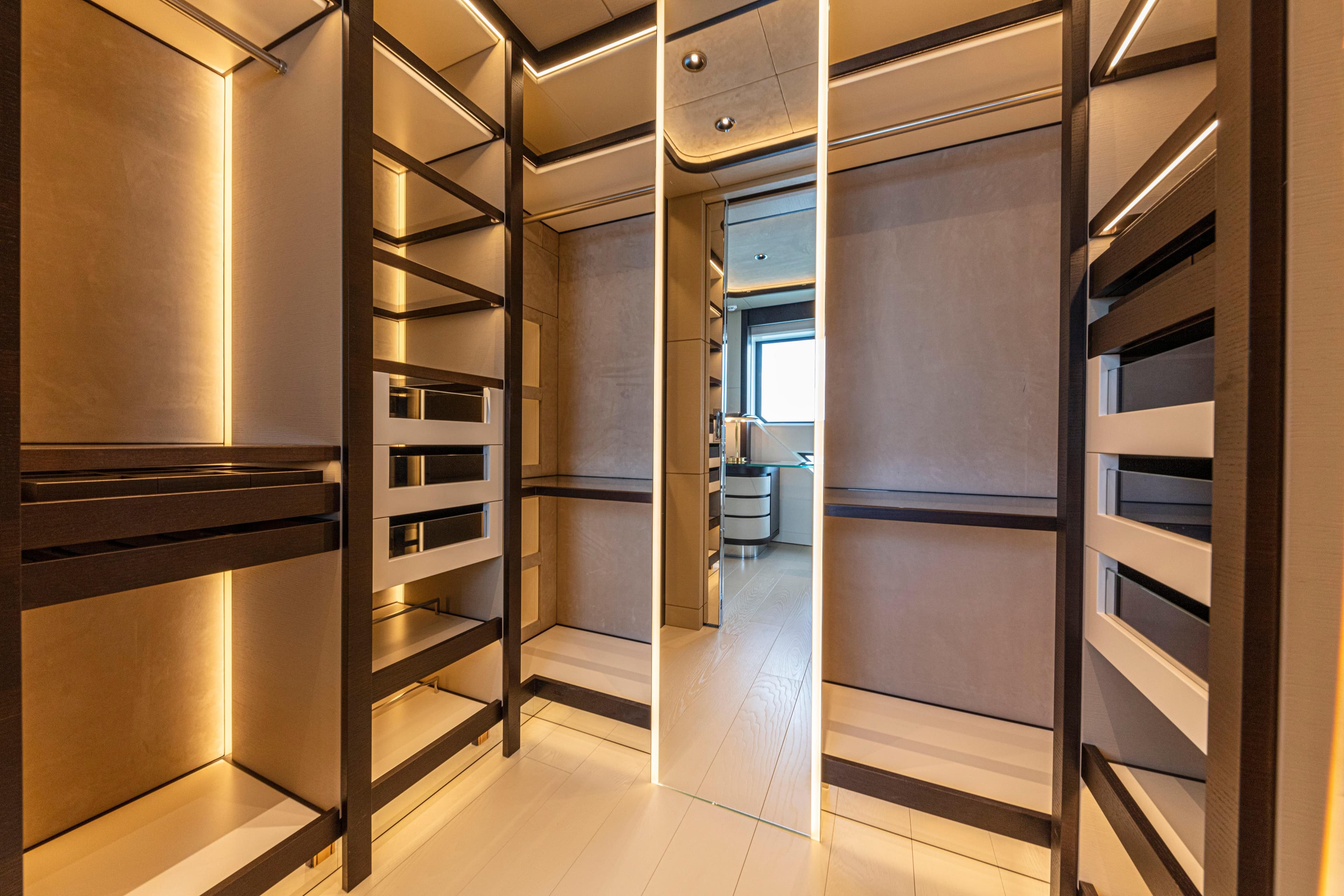 Luxurious walk-in closet on Ocean King Ducale 120 yacht, 2027 model, with elegant lighting.