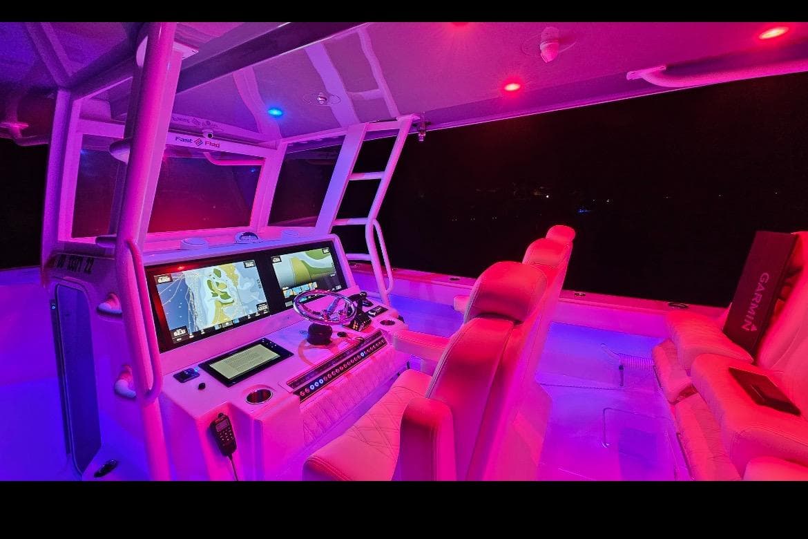 2023 Invincible 46 Catamaran cockpit with illuminated controls and seating at night.