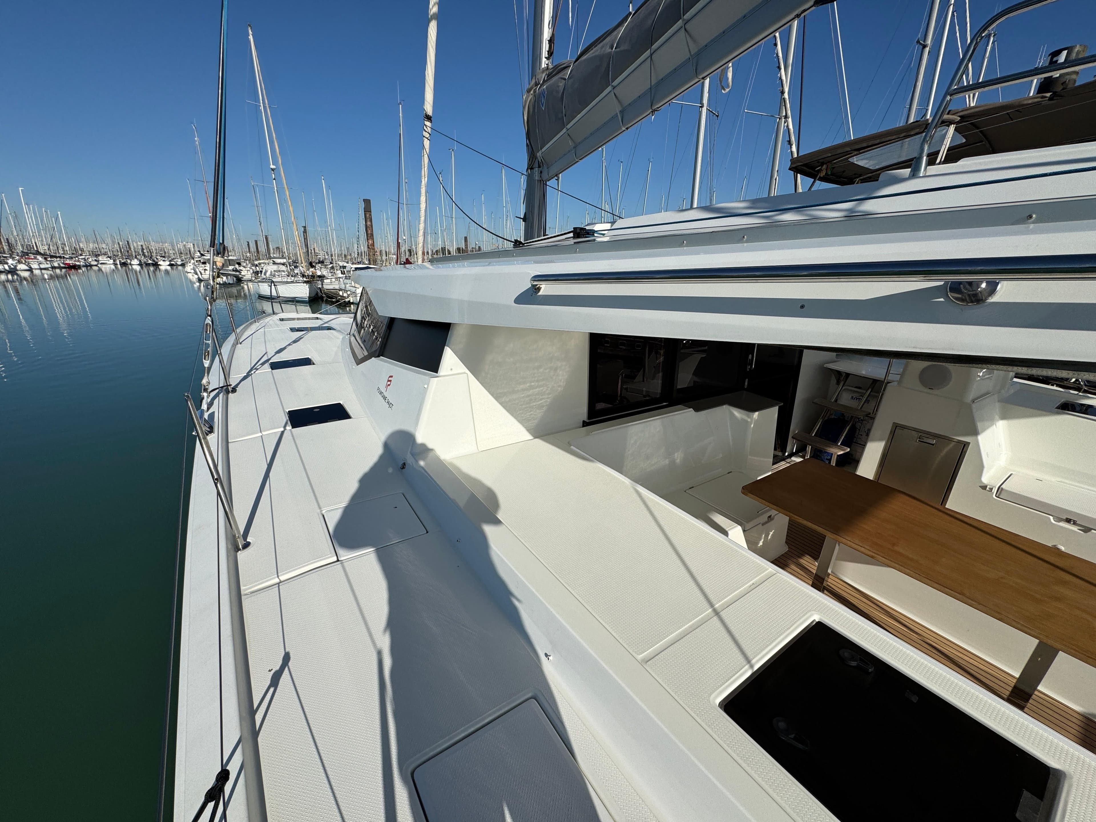 2019 Fountaine Pajot Saona 47 catamaran docked in a marina, showcasing sleek deck design.