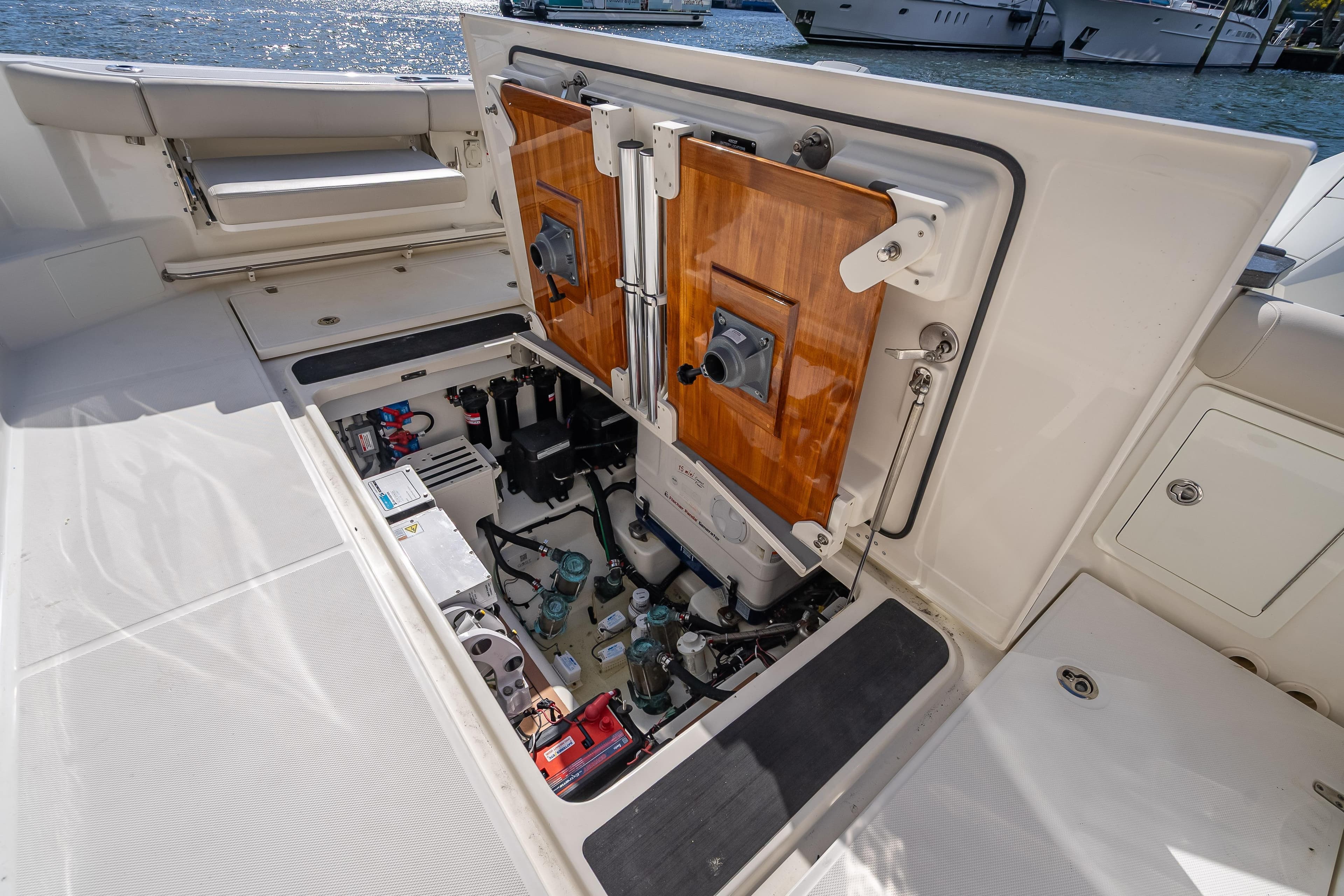 Open engine compartment of 2021 Boston Whaler 405 Conquest boat, docked by the water.