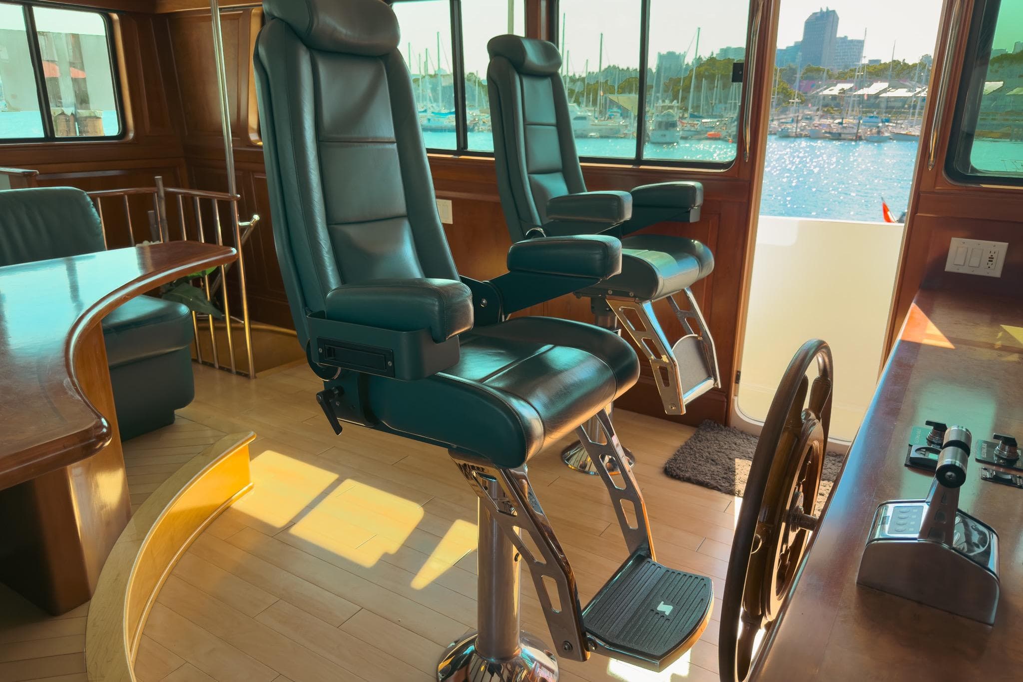 Pilothouse interior of 2002 Darling Yachts Custom Aluminum, featuring leather chairs and helm.