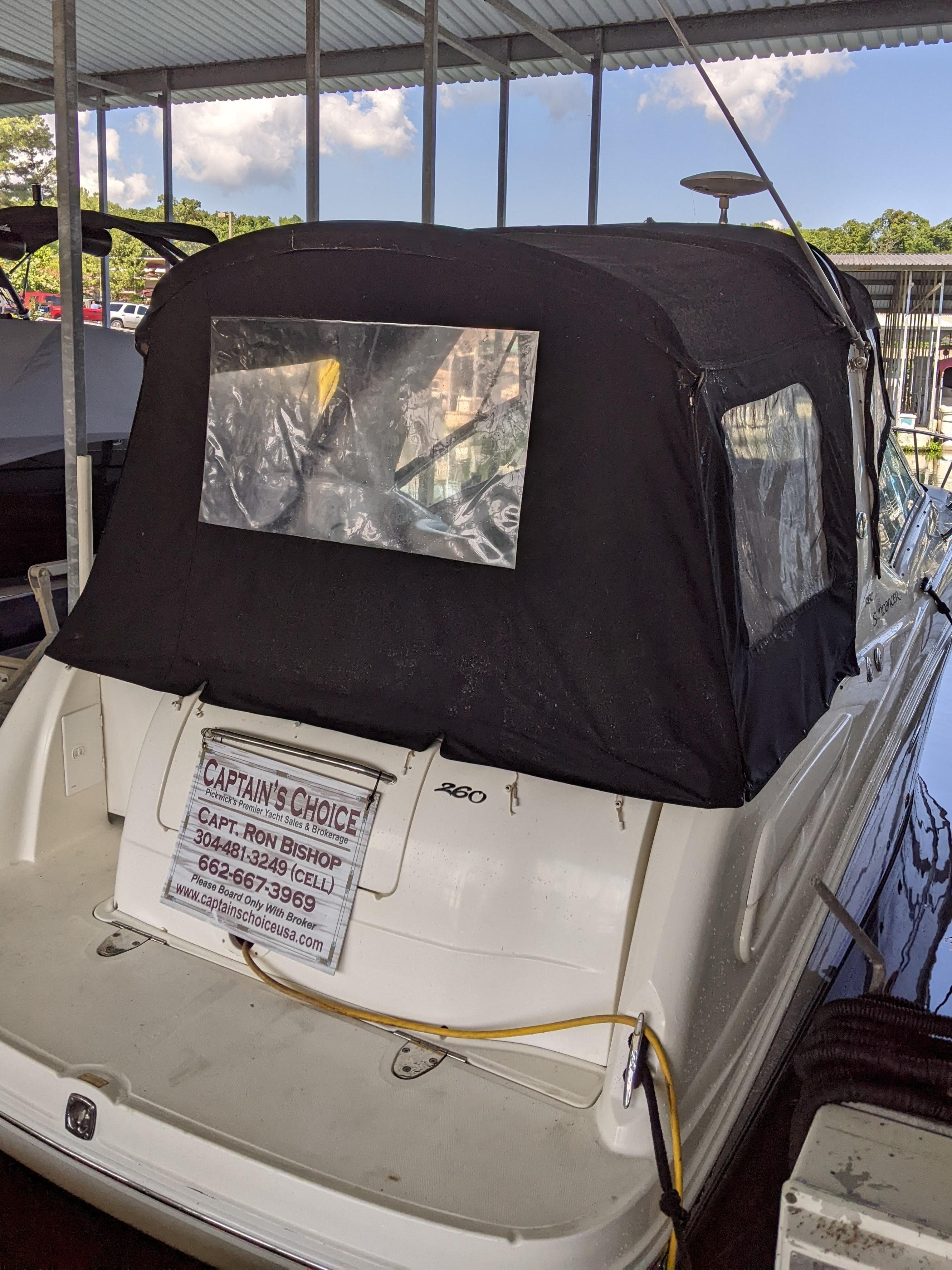2005 Sea Ray 260 Sundancer with black cover docked in marina.