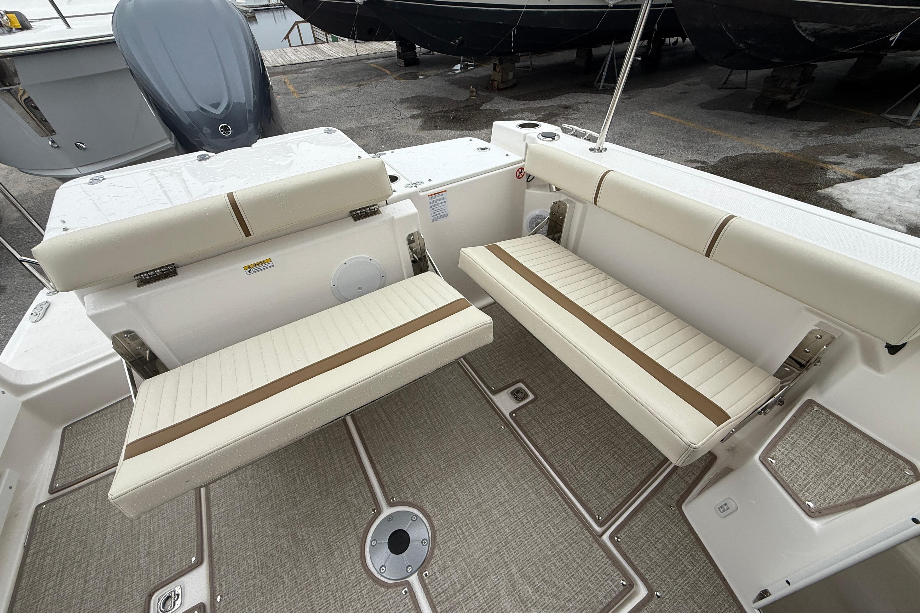 2026 Ranger Tugs R-27 boat interior with beige seating and carpeted flooring.